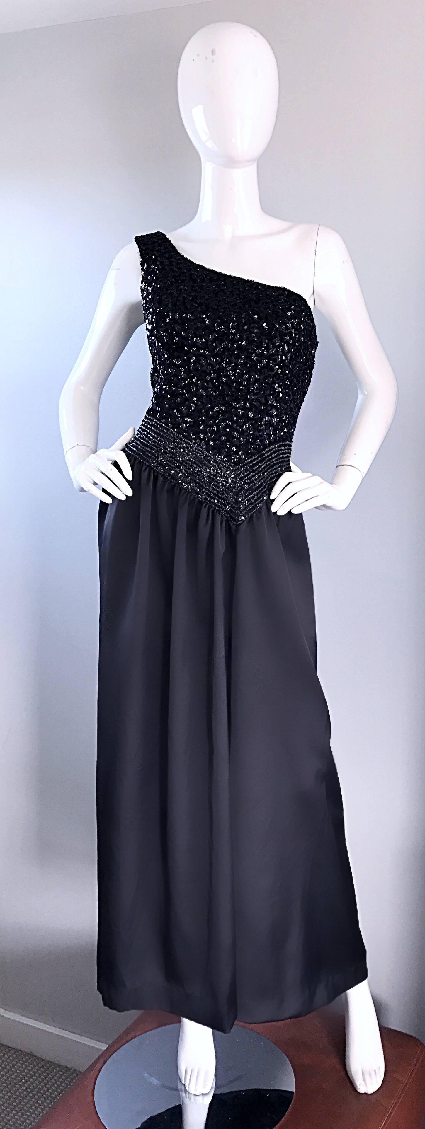 Increíble vestido de noche vintage de los años 70 con un solo hombro, de seda negra y lentejuelas, de inspiración griega. Presenta miles de lentejuelas y cuentas cosidas a mano por todo el corpiño. La falda de suave seda negra fluye con movimiento.