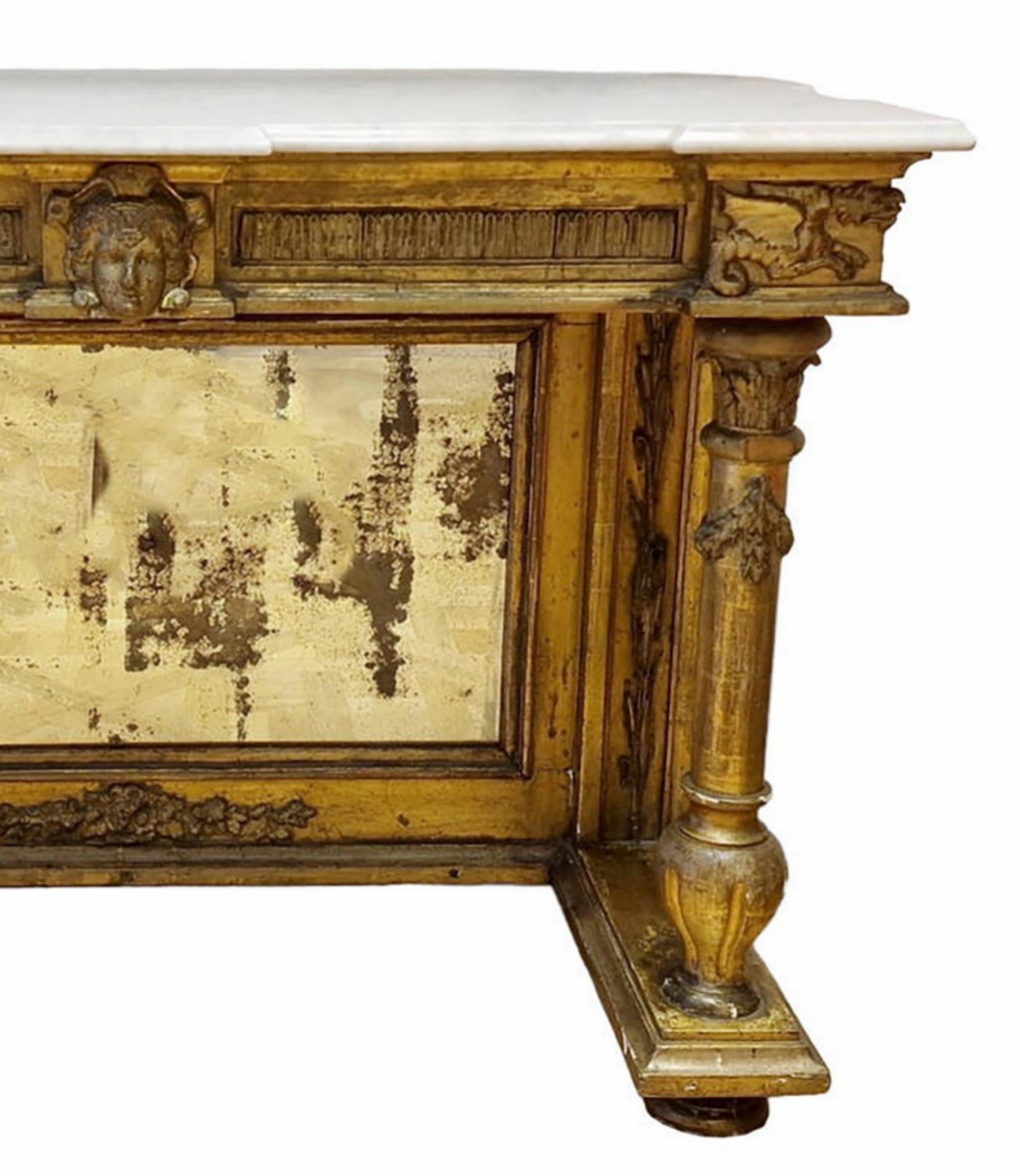 Amazing 19th CENTURY Important Console Empire Napoleon III
In gilded wood carved with dragons and a mascaron head, resting on two columns at the front and a large vertical spacer holding a mirror at the back. 
Topped with a white Carrara marble