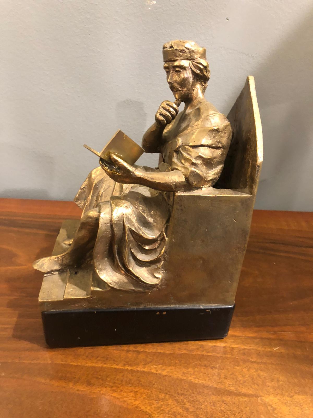 The gilded bronze sculpture of this King seated on his throne, wearing his crown, while he is absorbed in reading a book is very rare and particular. The figure stands elegantly, and the faded and somewhat worn gilt bronze surface shows a beautiful