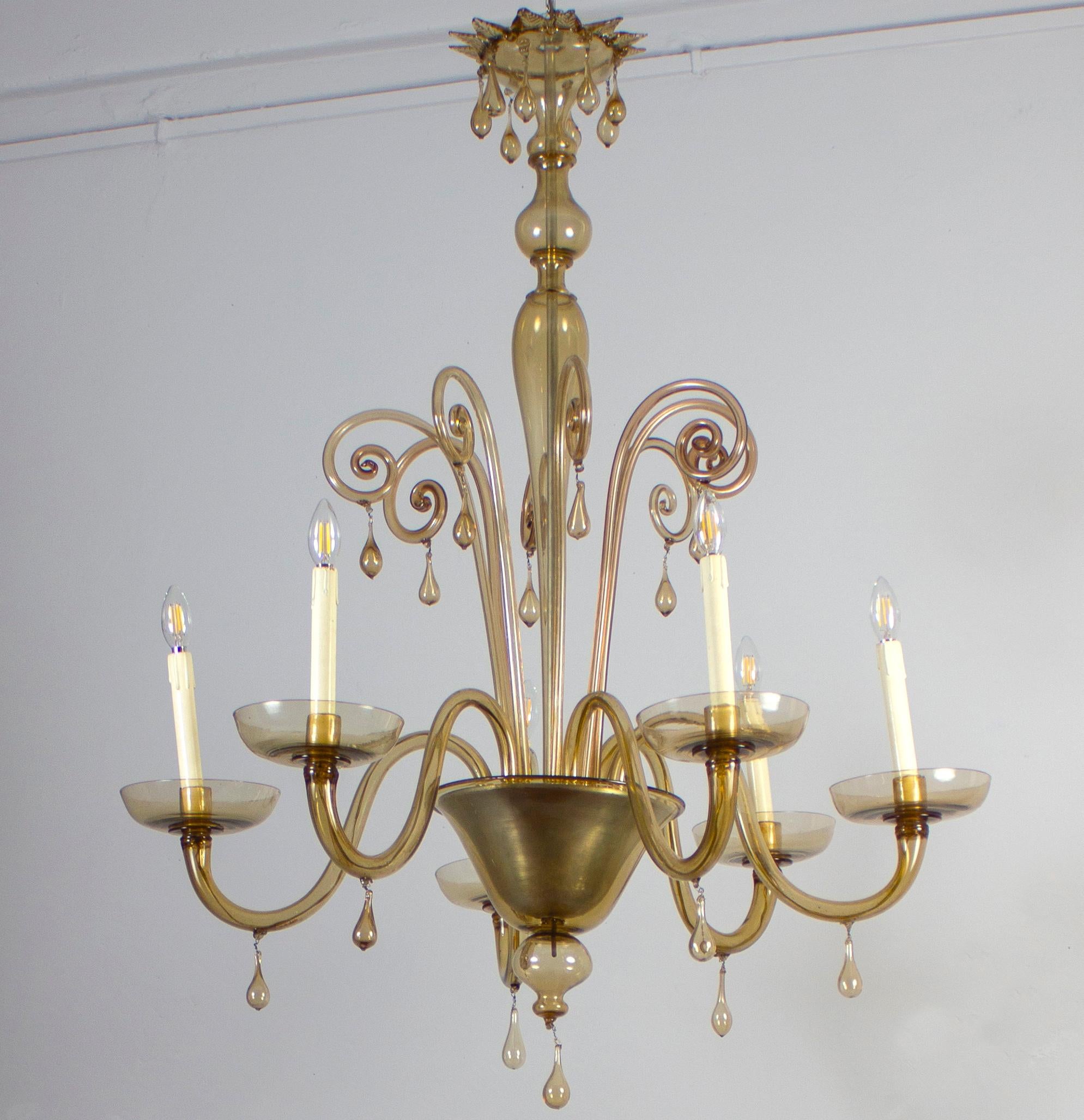 This elegant amber color chandelier  features 6 arms .
Cleaned and re-wired, in full working order and ready to use. In excellent vintage condition. The  glasses, all original and in good condition, are without chips or cracks. This light fixture