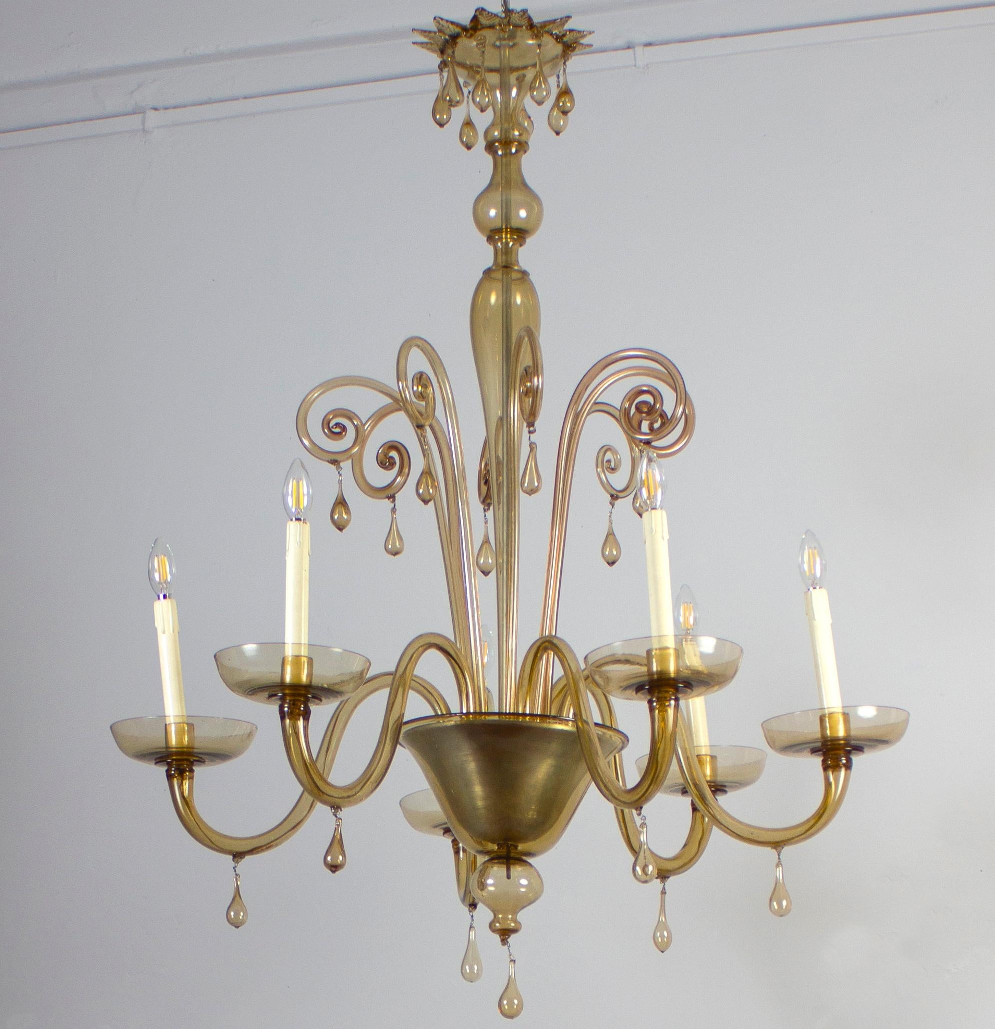 Questo elegante lampadario color ambra  Caratteristiche 6 bracci.
Pulito e ricablato, perfettamente funzionante e pronto all'uso. In eccellenti condizioni vintage. Il  Gli occhiali, tutti originali e in buone condizioni, sono privi di scheggiature o