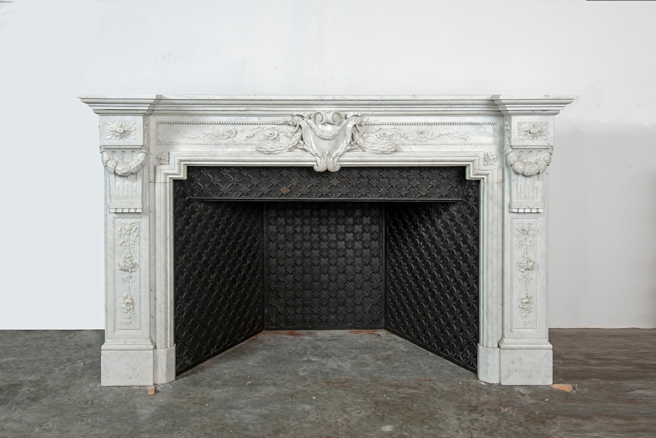 Spectacular and Amazing French Louis XVI style fireplace mantel in beautiful Italian Carrara white marble.

This mantel is decorated with exquisite and exuberant carvings, with a beautiful decorative cast iron interior.

It is in a lovely