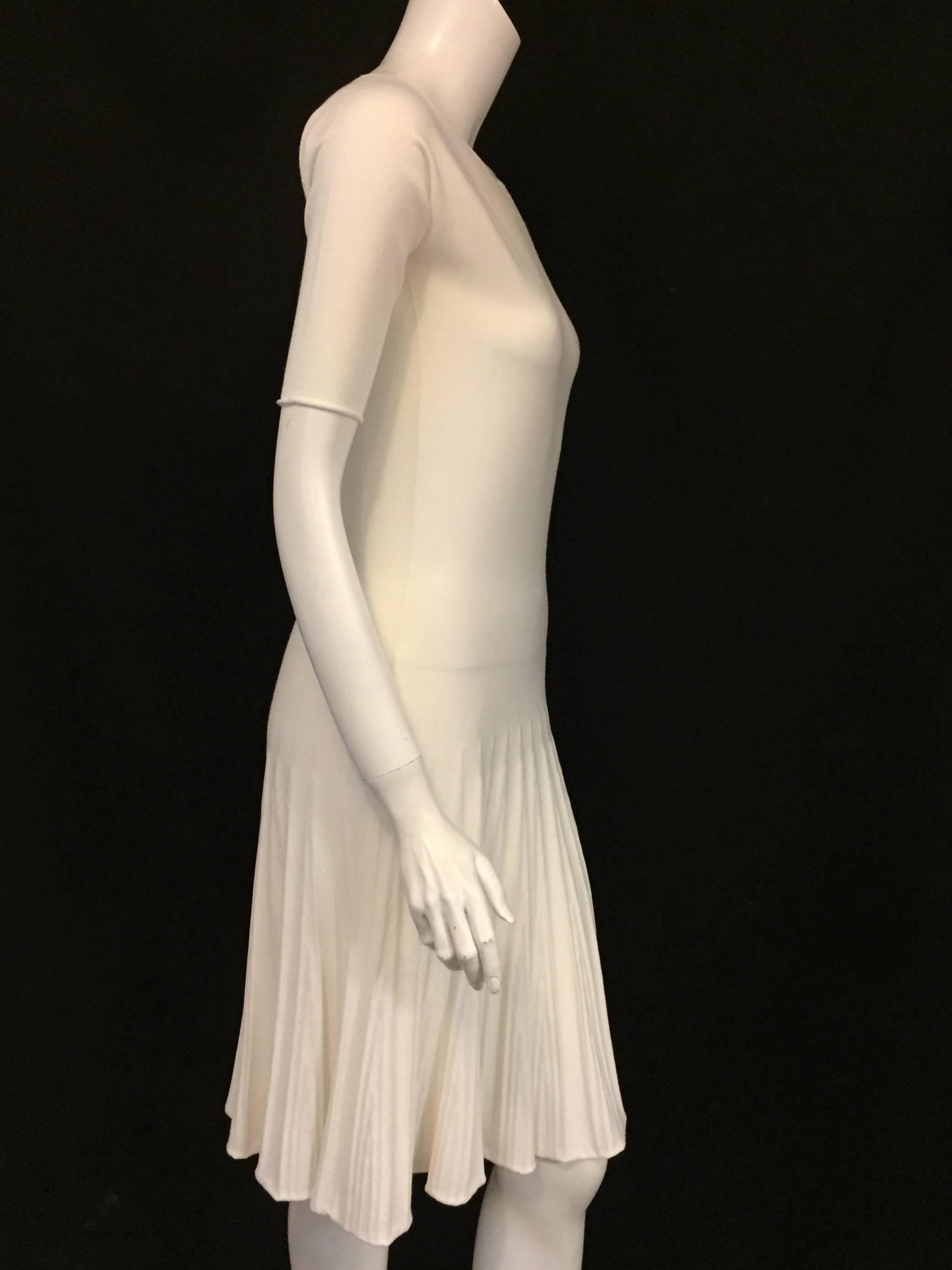 Remarkable Armani Ivory Dress with tapered sleeves to just above the elbows.  The faux pleats at the bottom of the dress give it a playful twirl at the hem, a classically and vivacious Armani signature.  Minimalist and discreet but ready to be