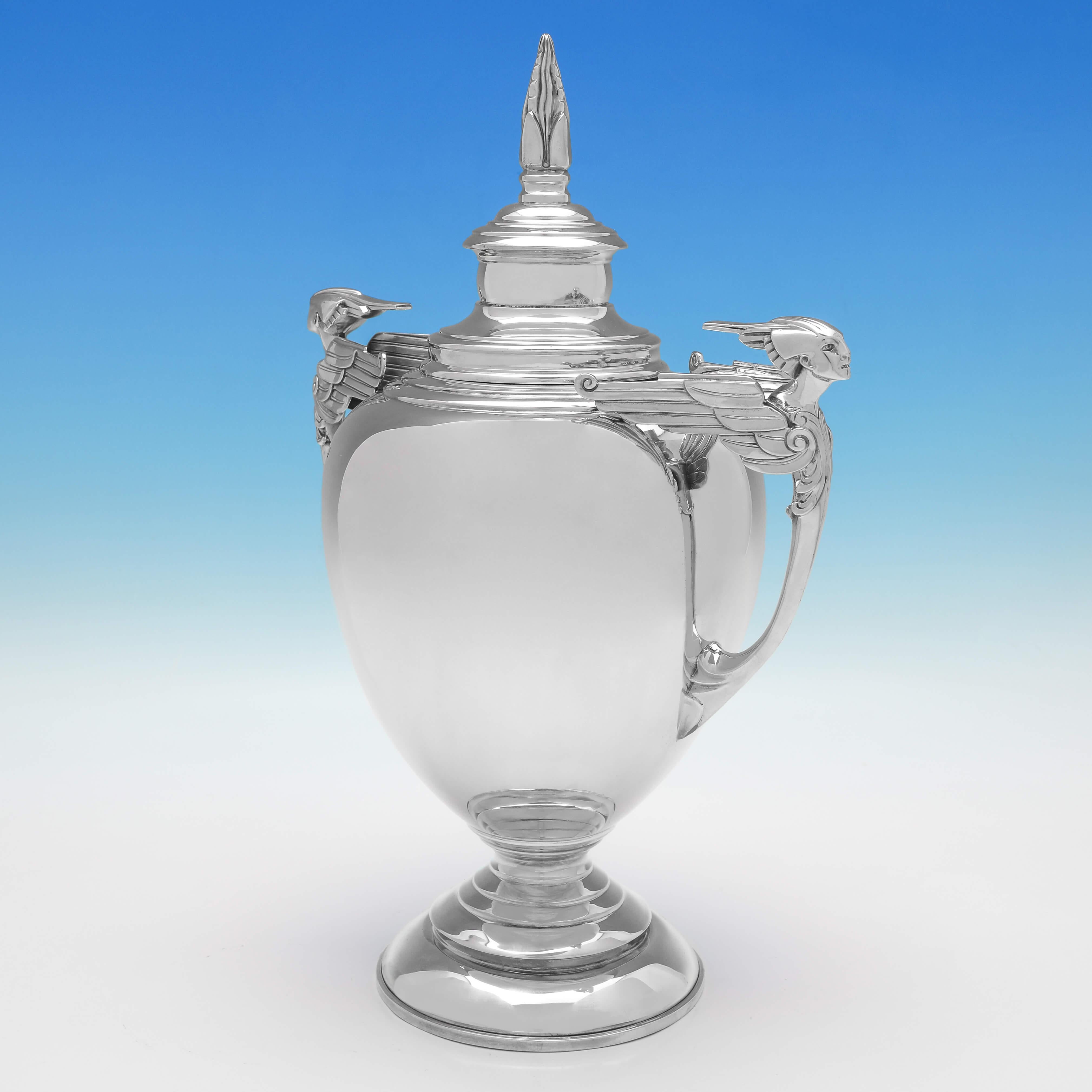 Hallmarked in London in 1931 by William Bruford & Son, this very handsome, Sterling Silver Trophy, is in the Art Deco taste, with striking handles, and a stepped base and lid. 

The trophy measures 14.5