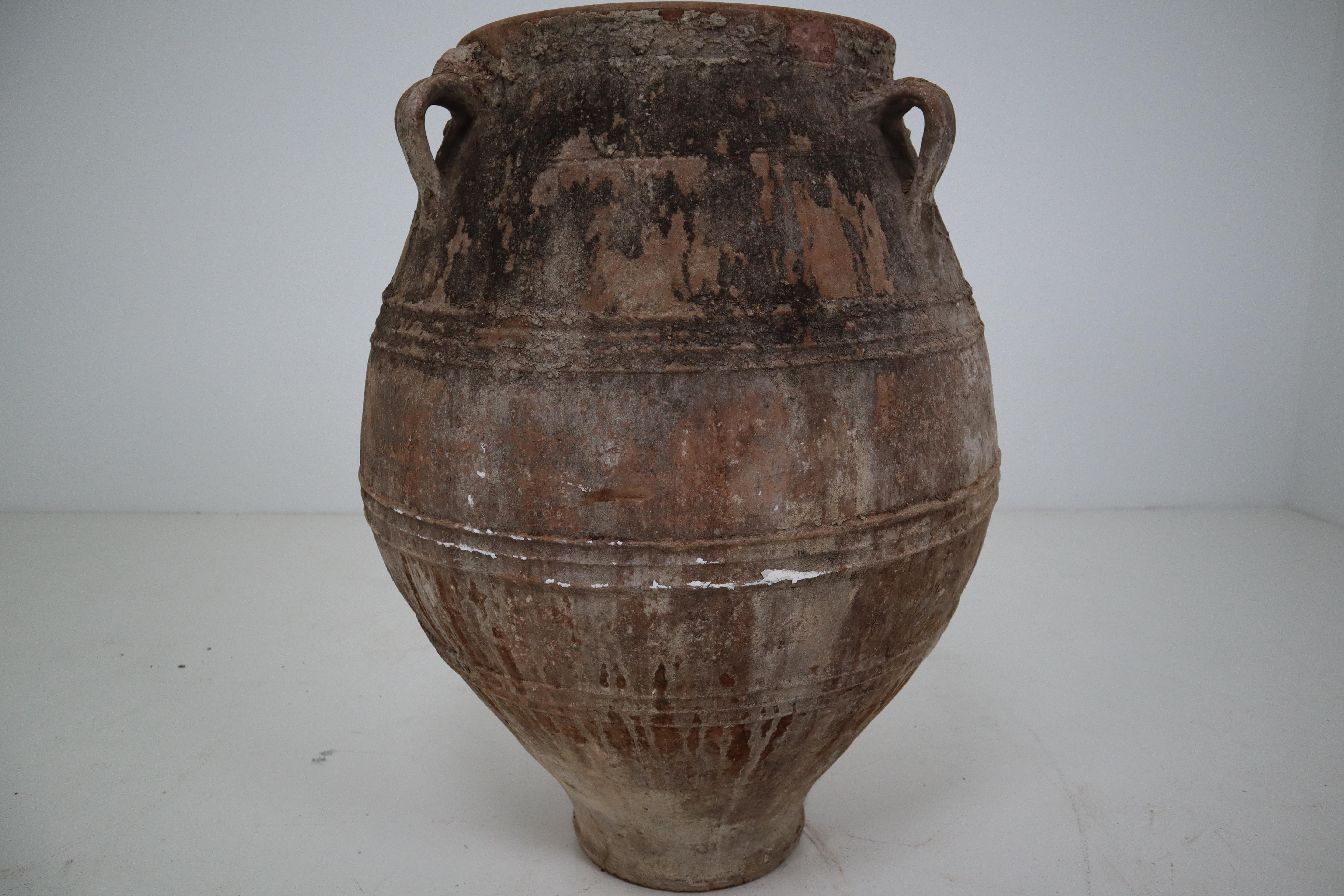 A large antique three-handled painted terracotta urn from the late 19th century Greece, with white finish and rounded belly. Picture this large 1880s urn in its former life, on a shaded terrace under an olive tree overlooking the Mediterranean Sea