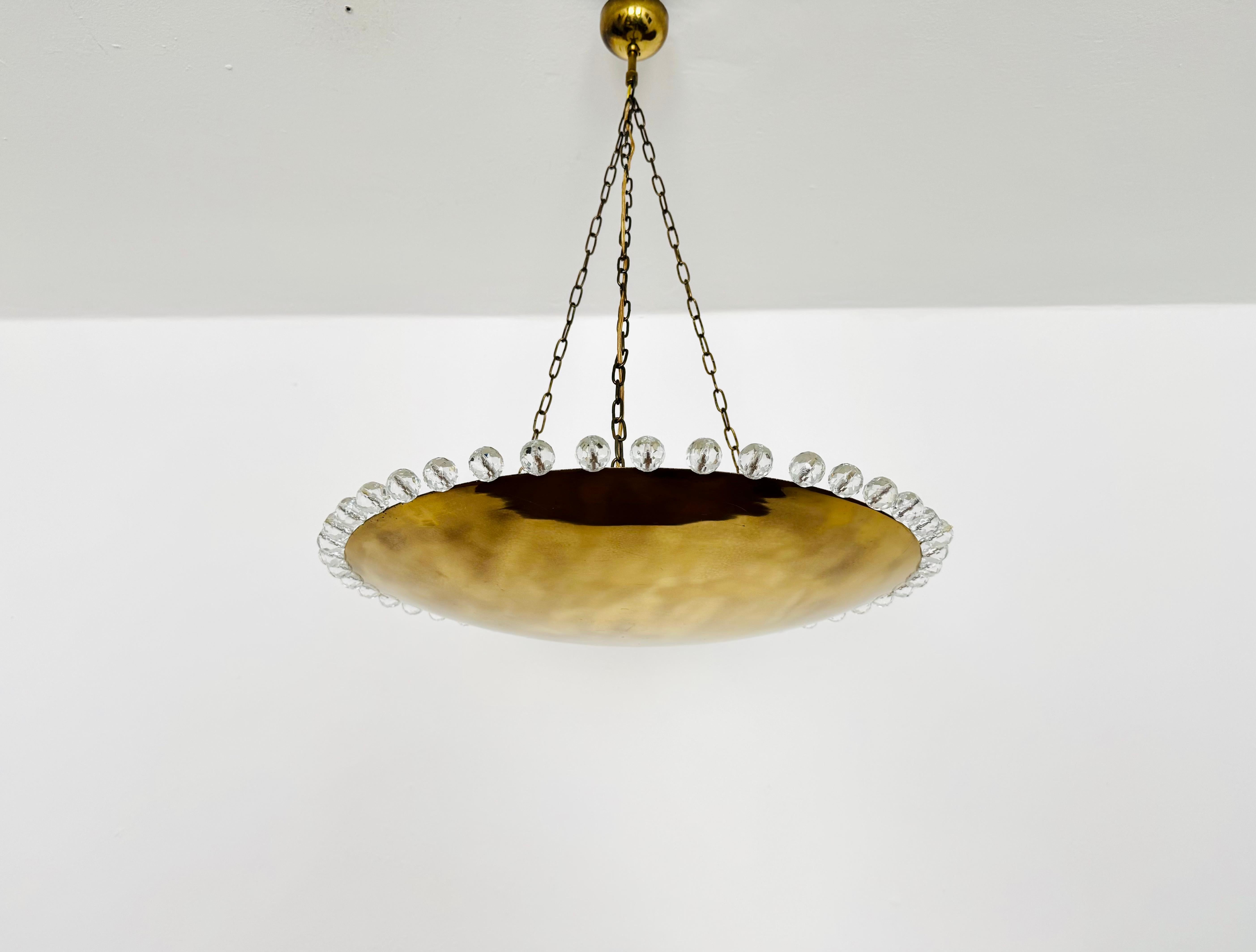 Very rare pendant lamp with a wreath of crystal balls from the 1950s.
Stunning design and a rare collector's item.
A very comfortable light is created.

Manufacturer: Rupert Nikoll

Condition: 

Very good vintage condition with slight signs of