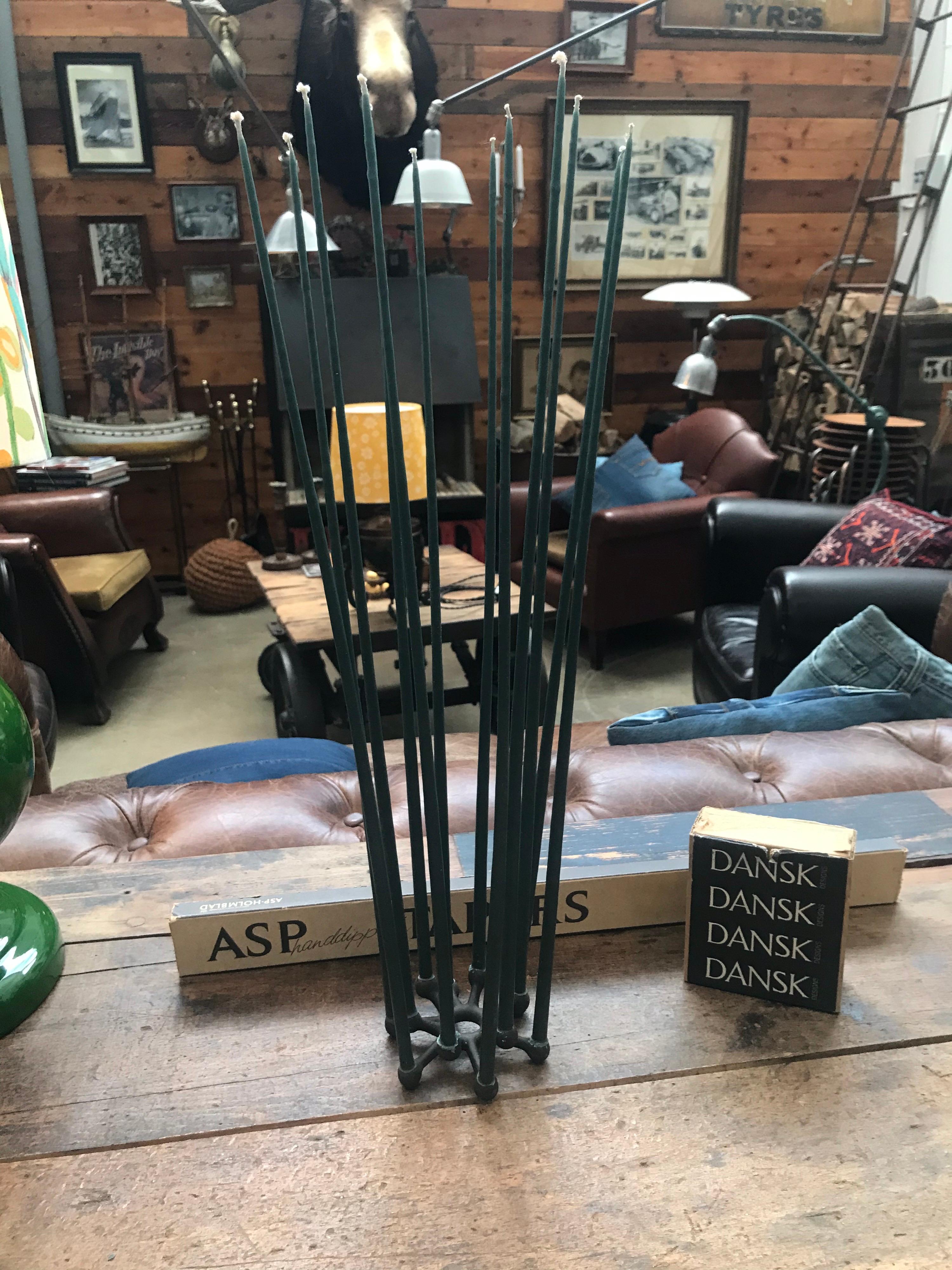 Amazing Danish cast iron candleholder by Jens H. Quistgaard for Pato. 
Comes with a box of 12 hand dipped tappers candles NOS new old stock in the original box.

Jens Harald Quistgaard (April 23, 1919 – January 4, 2008) was a Danish sculptor and
