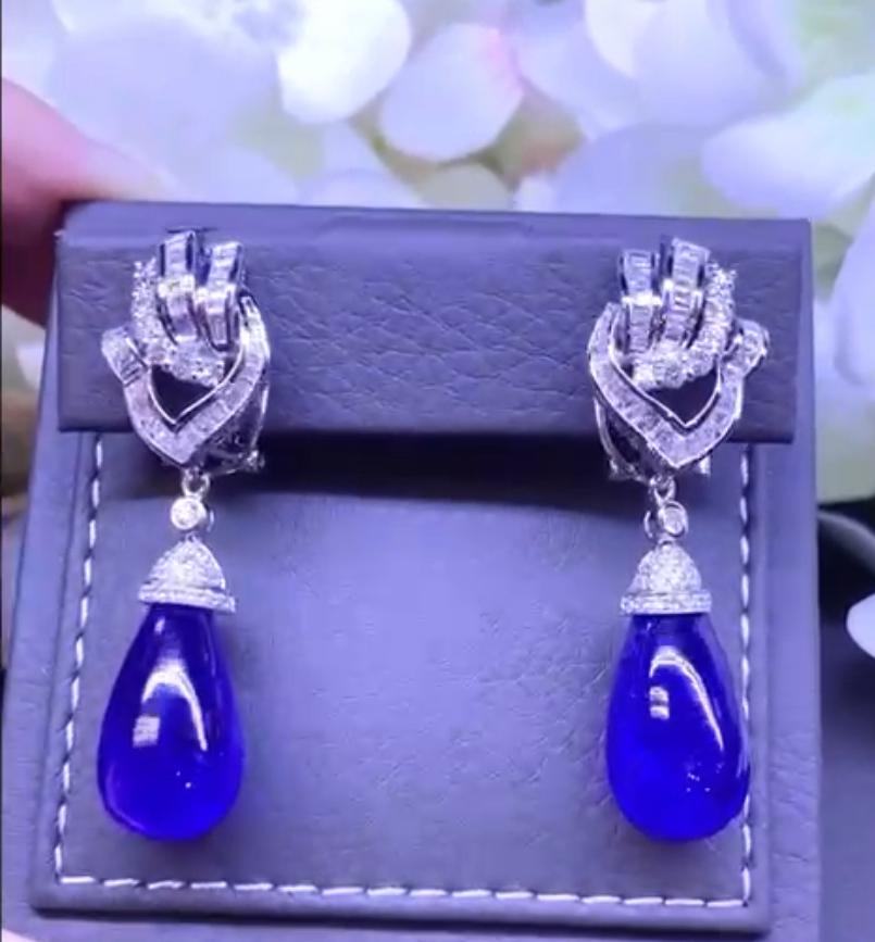 An exquisite and chic design, by Italian designer.
Earrings come in 18k gold with two piece of Natural Tanzanites from Tanzania of  24 + 25  carats, tot 49 carats in cabochon cut , fine quality, spectacular color, and round brilliant  and baguettes