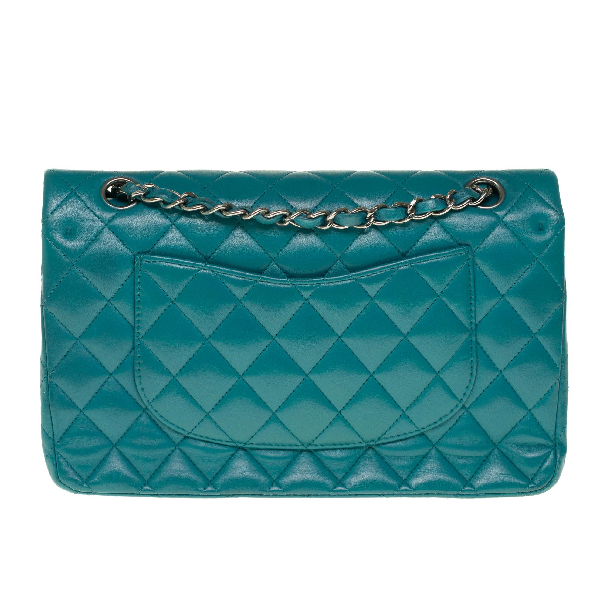 Beautiful Chanel 2.55 handbag in green nappa leather, chain handle intertwined with green leather allowing a hand or shoulder or shoulder strap.

Silver metal flap closure.
A patch pocket on the back of the bag.
Lining in green leather, a double