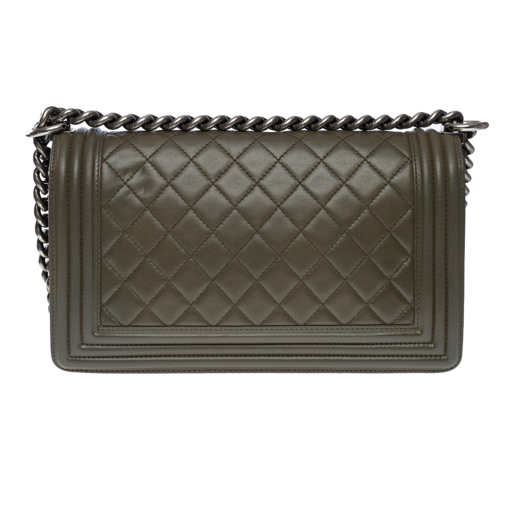 The iconic Chanel Boy Old Medium shoulder bag in khaki quilted leather, ruthenium metal hardware, an adjustable ruthenium metal chain handle for shoulder or shoulder support

A ruthenium metal closure on flap
Inner lining in grey canvas, one patch