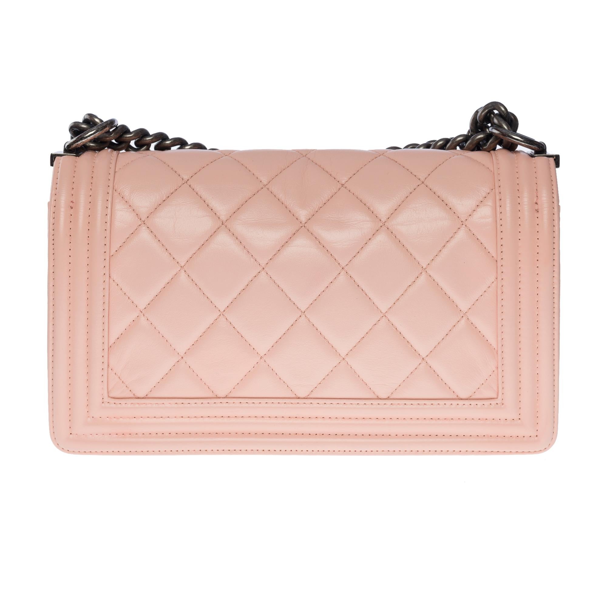 The iconic Chanel Boy old medium shoulder bag in pink quilted leather, with ruthenium metal hardware, an adjustable ruthenium metal chain handle for shoulder or crossbody support

A ruthenium metal closure on flap
Inner lining in pink canvas, one