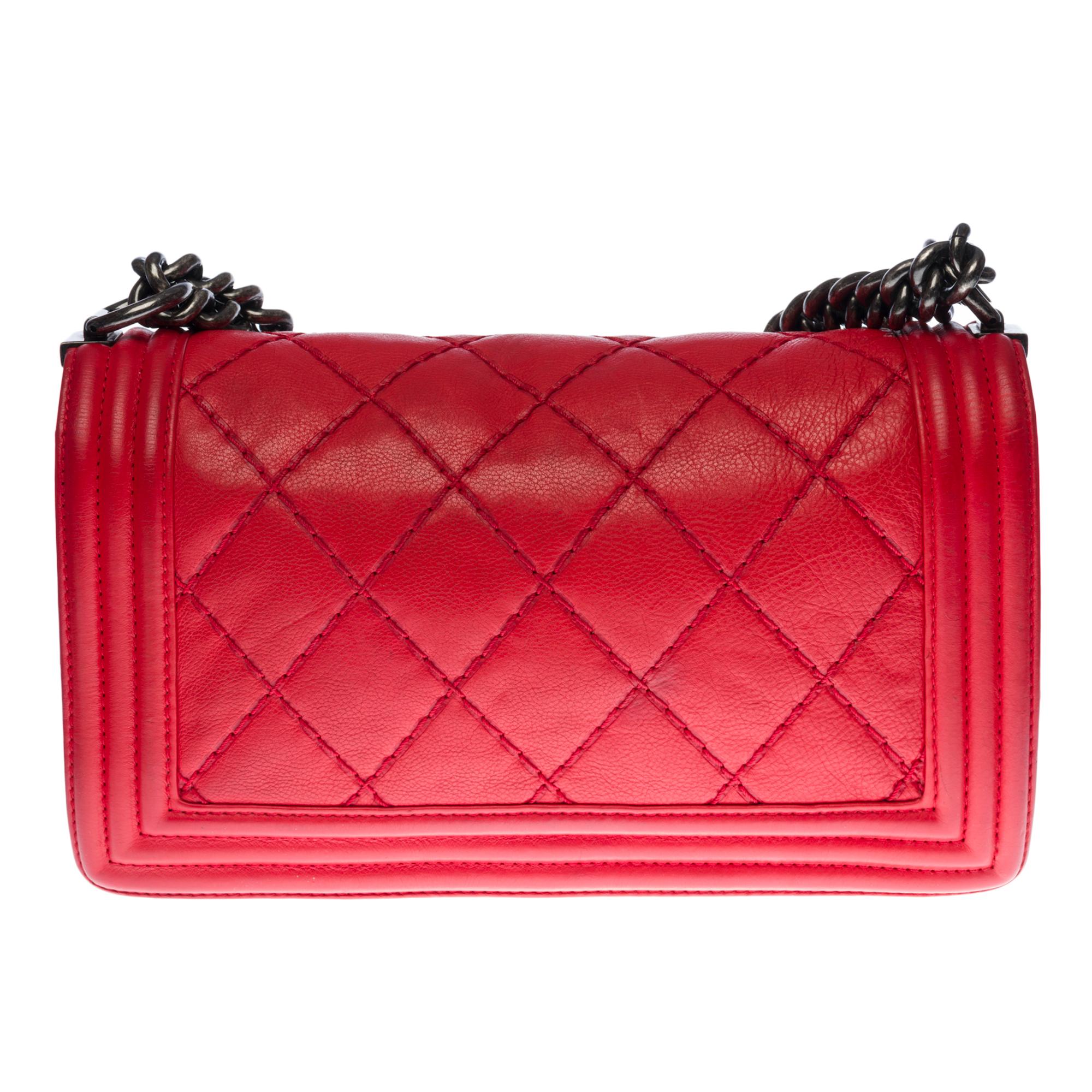 The iconic Chanel Boy shoulder bag old medium in red quilted leather, ruthenium metal hardware, an adjustable ruthenium metal chain handle allowing a shoulder or shoulder support

A ruthenium metal closure on flap
Grey canvas lining, one patch