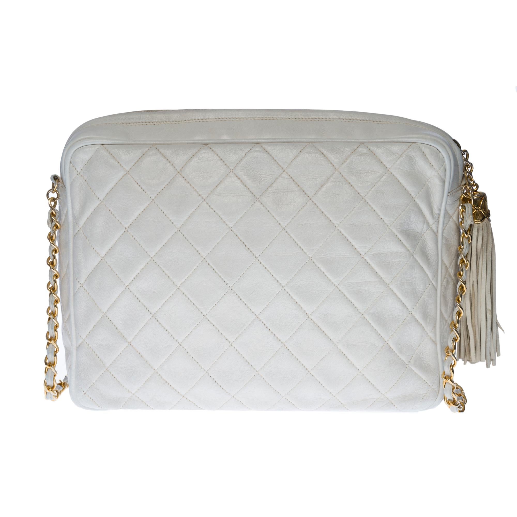 Chanel Camera white quilted leather handbag with gold-tone metal hardware and a gold-tone metal chain handle for hand, shoulder or crossbody support.

It’s a zip fastener.
One pocket with flap closure on the front of the bag
Lining in white leather,
