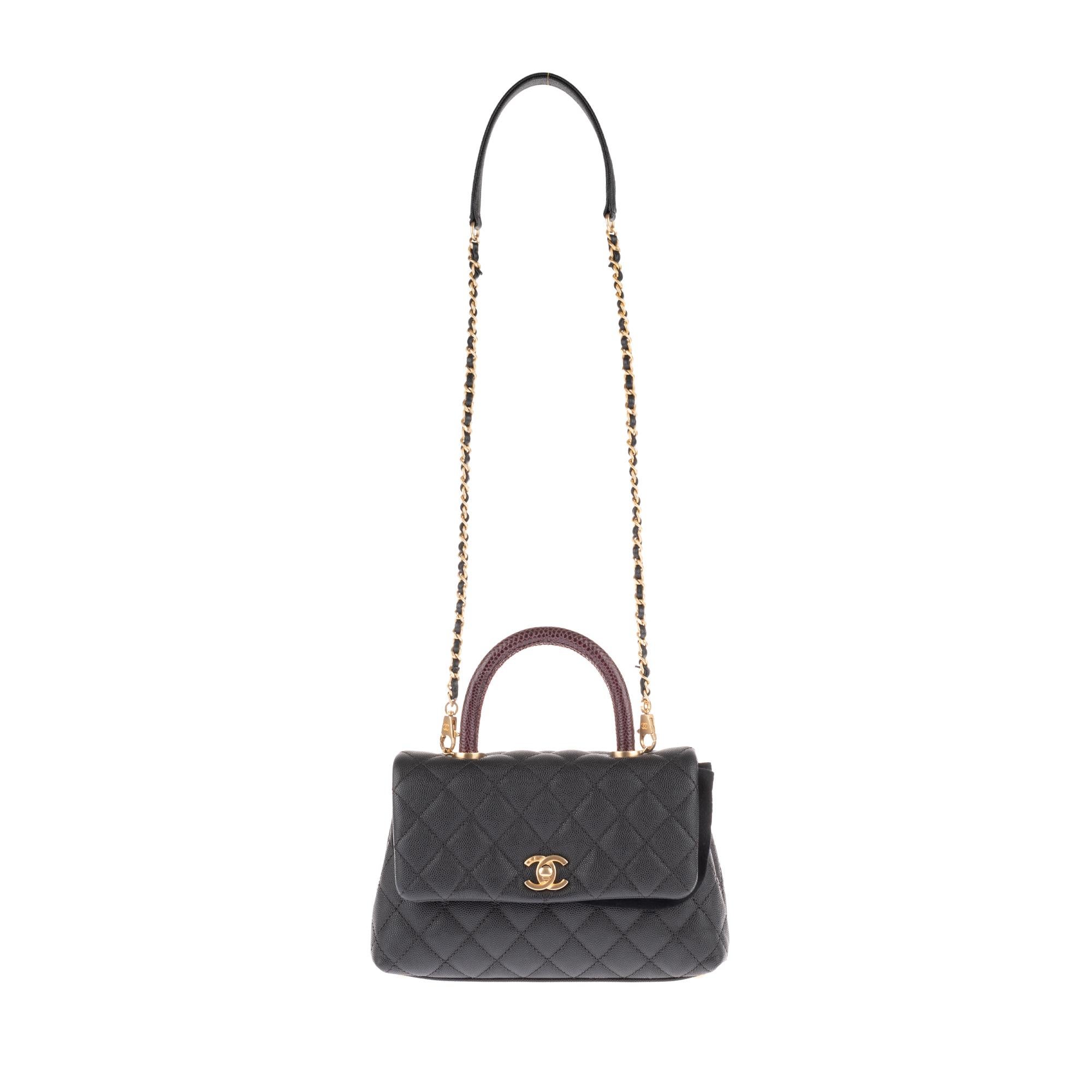 Stunning and original Chanel Coco Handle handbag in black caviar leather, gold metal trim, brown lizard handle, a gold metal chain handle interlaced with black leather allowing a handheld or shoulder or shoulder strap.

Closure by flap.
Black