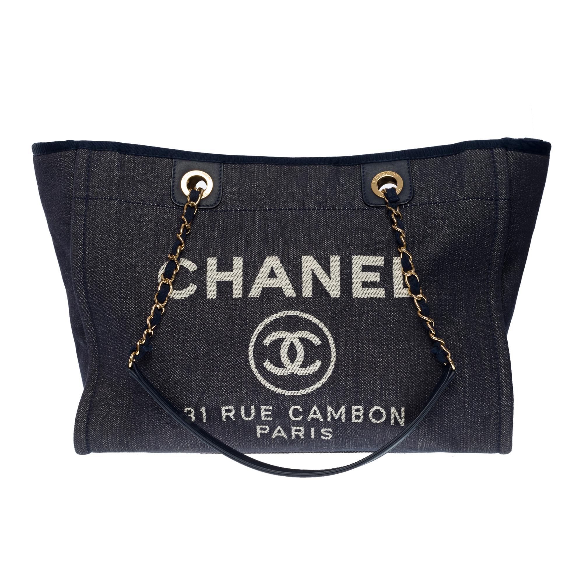 Gorgeous Chanel Deauville Tote bag in blue denim canvas, gold metal hardware, a double handle in gold metal interwoven with blue denim canvas allowing a hand and shoulder support

Closure by double golden magnet
Beige canvas lining, two patch