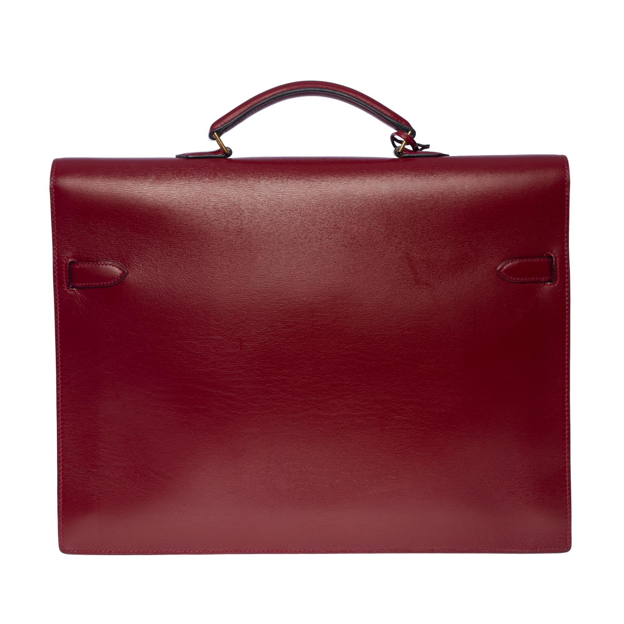 Very refined & Rare Hermès Kelly Dépêches in red H box calf leather (burgundy), gold-plated metal hardware, simple red leather handle allowing a hand carry

Flap closure 
Red suede interior, 3 compartments
Signature: 