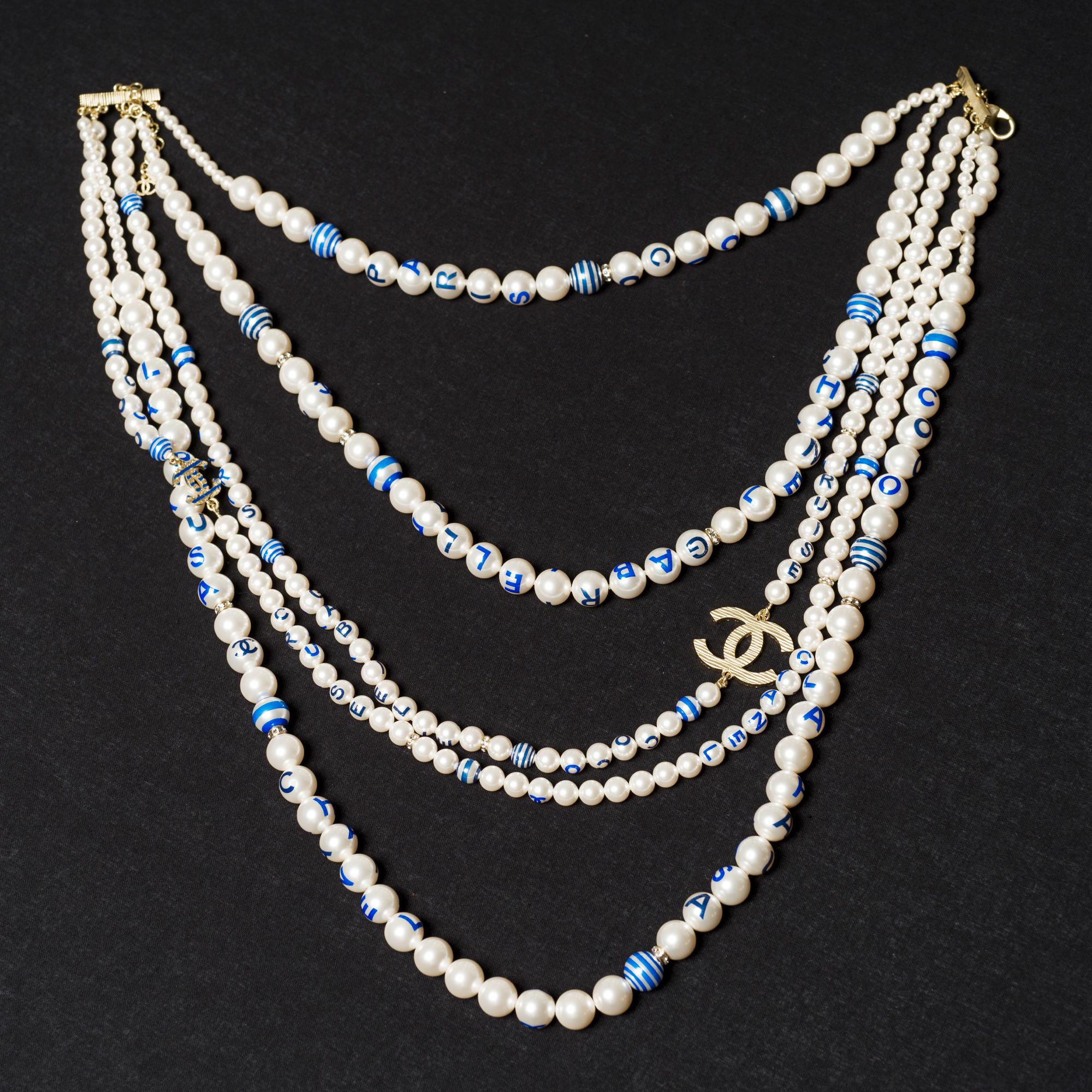 Chanel​ ​CC​ ​long​ ​necklace​ ​in​ ​white​ ​pearly​ ​pearls​ ​and​ ​gold​ ​metal​ ​with​ ​blue​ ​inscriptions​ ​in​ ​5​ ​rows

Length:​ ​37cm

Reference:​ ​101449

General​ ​condition:​ ​7.5/10
Sold​ ​with​ ​box
