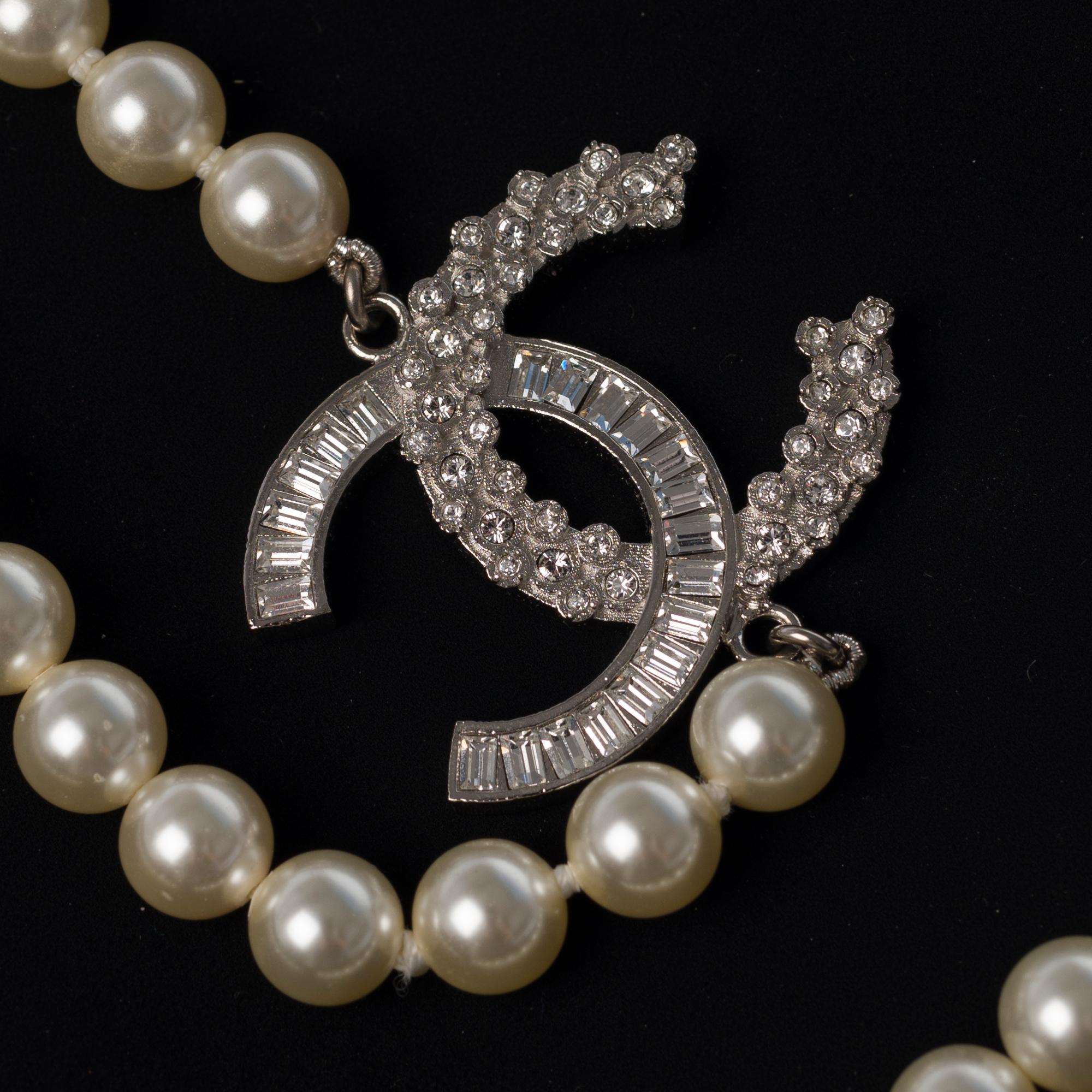 Chanel Classic Strand Lined Pearl Necklace/ Necklace with CC Interlocking fantaisie Crystal with Silver Striated Metal hardware.
Length: 120cm (60 folded in 2).
Sold with box, ribbon and box.
In excellent condition.