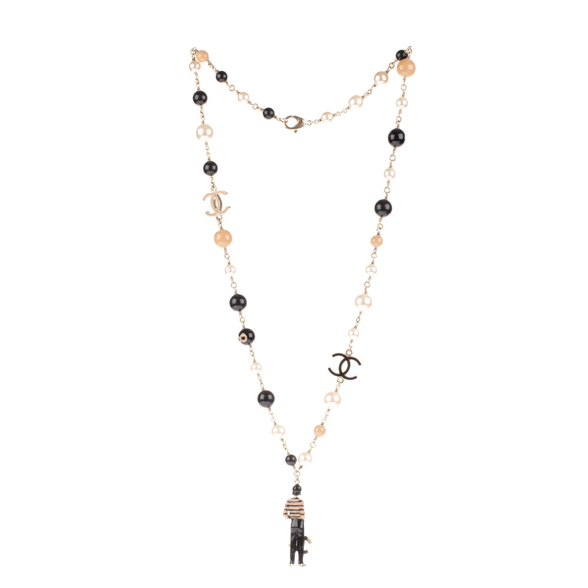 Gorgeous Chanel necklace released on the occasion of the brand’s 100th anniversary.
Very rare collector piece with a metal chain threaded with fancy black beads, taupe, white and metal charms stamped CC. The necklace wears to its extreme a metallic