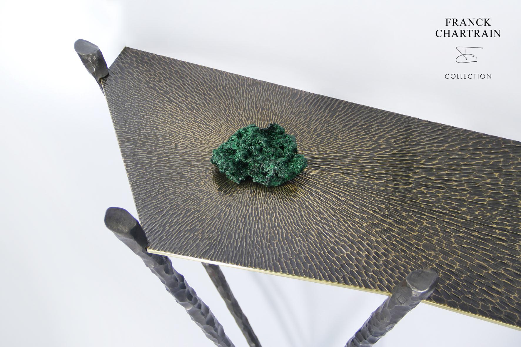 Cette magnifique table console a été fabriquée à la main par Franck Chartrain, un célèbre artiste-designer français.

Le plateau angulaire et élancé en bronze poli est gougé d'arêtes vives.
Sa texture travaillée avec une finition satinée foncée