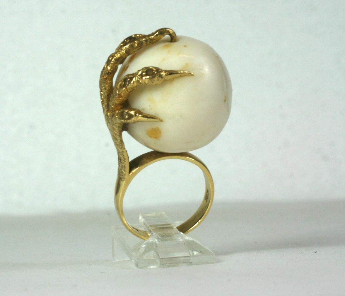 Étonnante bague à griffes en corail des années 1970 avec un corail blanc massif serti dans une monture à griffes texturée de 18k sertie de minuscules éclats de diamants.  Taille 6. Perle 20mm. Italie, 1970. 
VENTES NATIONALES UNIQUEMENT.