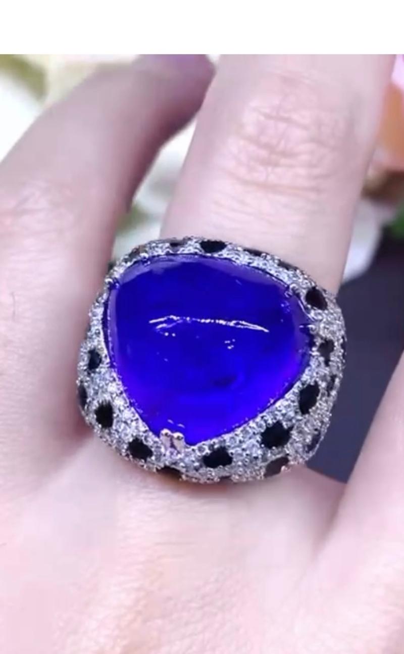 Design molto raffinato per questo magnifico anello in oro 18 carati con tanzanite naturale grande taglio cabochon ct 25,43, smalto nero e diamanti naturali taglio brillante rotondo ct 1,90 E/VS di prima qualità.
Realizzato a mano da un artigiano