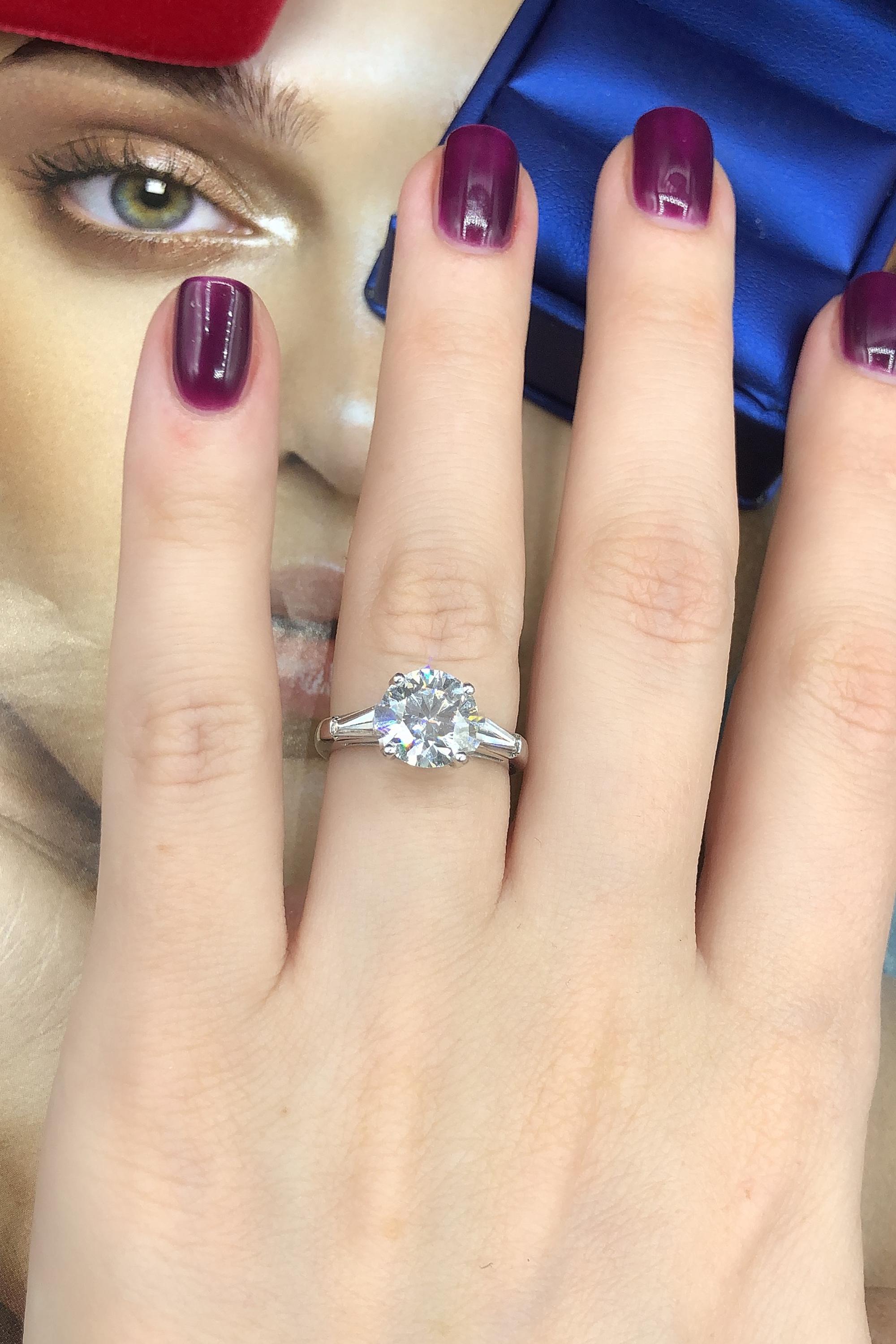 This is a beautiful certified Diamond ring round brilliant cut with a center 2.03 carat H color SI2 clarity enhanced Diamond and two side of Baguettes Diamonds with total weight of 0.48ct. The ring is unworn and comes AGI certificate and jewelry box.