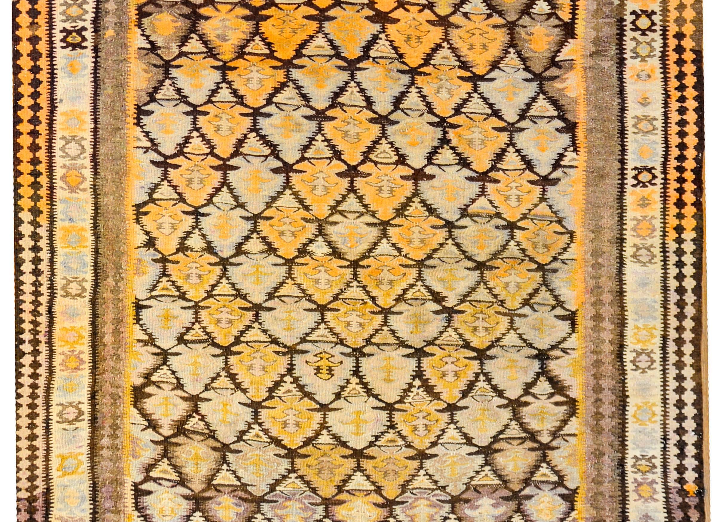 An amazing early 20th century Persian Qazvin Kilim rug with an all-over tree-of-life pattern woven with orange, lilac and natural wool colored vegetable dyed wool. The border is complex, with three distinct geometric patterns, with the central