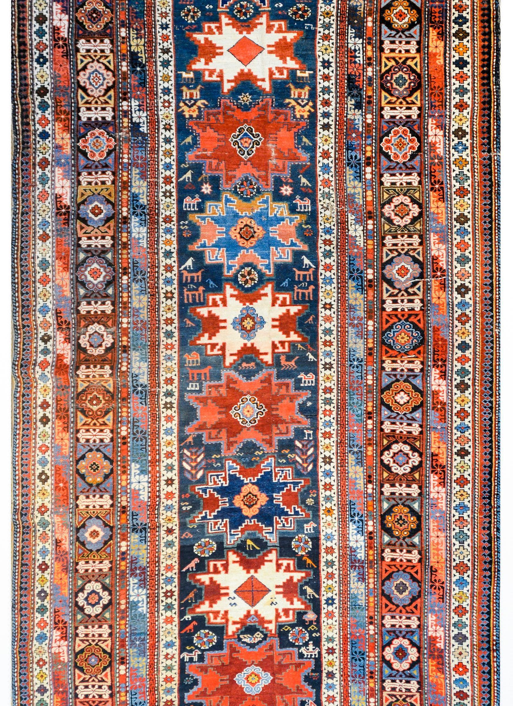 An amazing early 20th century Azerbaijani Shirvan runner with several stylized flower medallions woven in crimson, white, and indigo, on an abrash indigo background amidst a field of flowers and birds. The border is incredible with multiple stripes