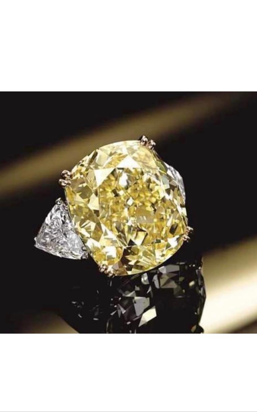 Magnificent classic design for this refined ring in 18k gold with a GIA certified natural fancy yellow diamond , cushion cut, of 5,01 carats, VVS2 clarity, so clean and brilliant, with two side natural diamonds in trillions cut .
A very piece of