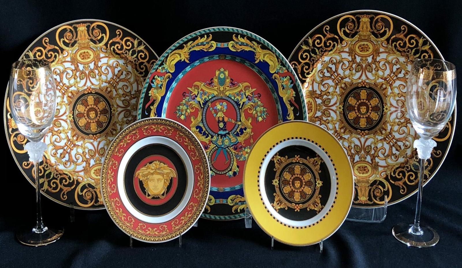 Amazing Gianni Versace Set by Rosenthal 
Rosenthal, designed by Gianni Versace, 
3 large and 2 small plates: Barocco, Le Roi Soleil, Medusa, porcelain, 
D. 18.5 and 31 cm; and 2 champagne flutes with Medusa heads and meanders in gold, H. 27