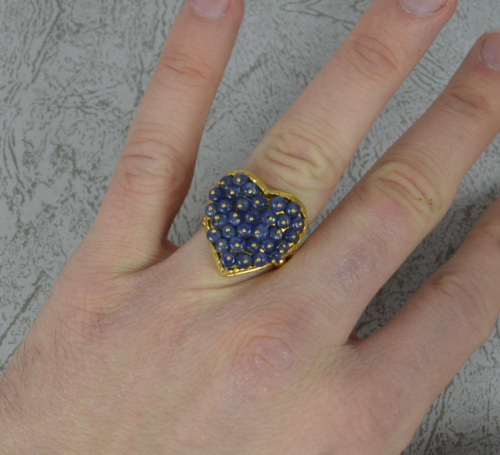 A superb 18ct Yellow Gold and Sapphire cluster ring. 
Designed with a heart shape front set with many round sapphire cabochon stones set gold pins to the centre of each.
Very heavy and solid piece.
20mm x 21mm cluster head.

CONDITION ; Excellent.