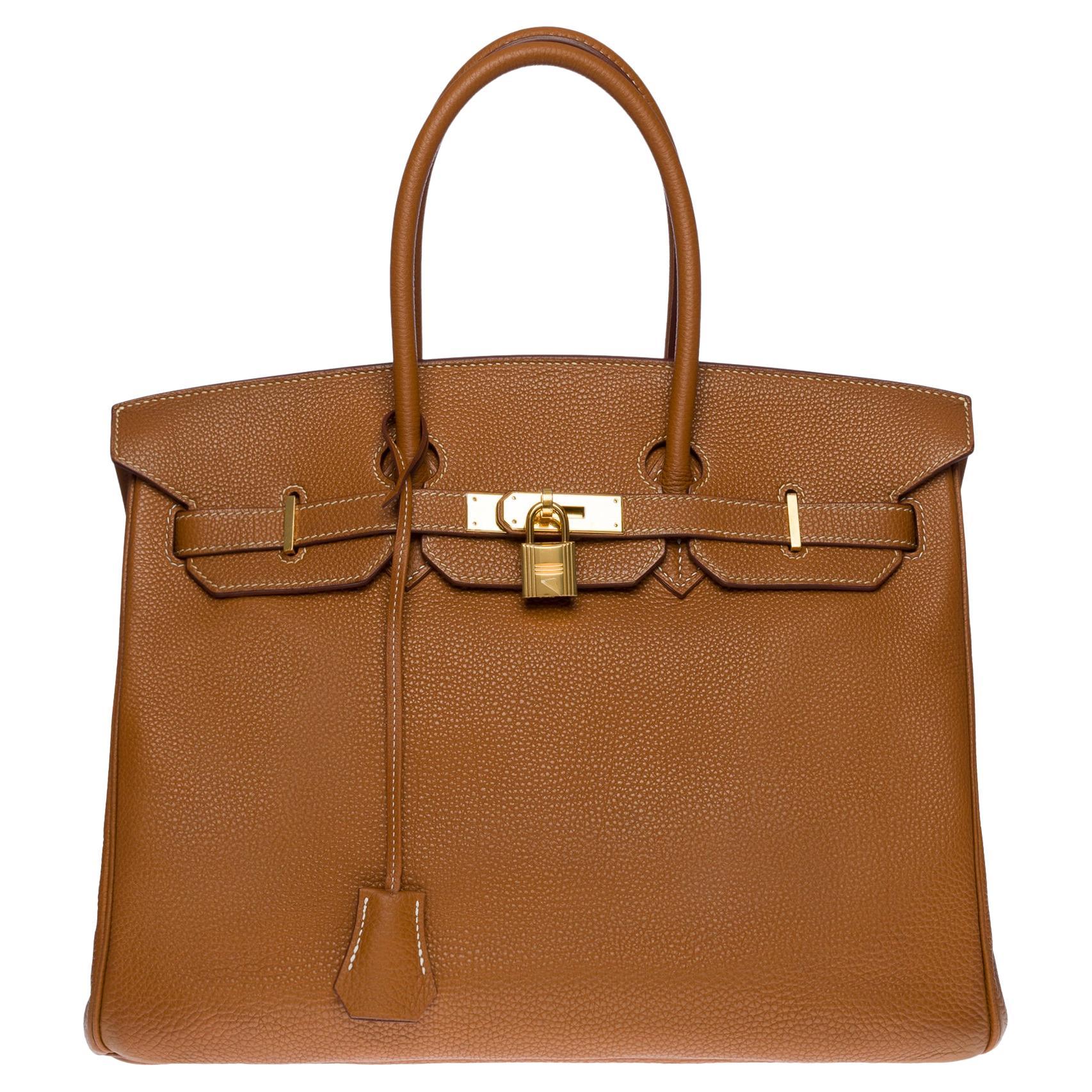 Beautiful Hermes Birkin 35 handbag in Camel (Gold) Togo leather with white stitching, gold metal hardware, double handle in gold leather allowing a hand-held

Flap closure
Inner lining in gold leather, one zippered pocket, one patch