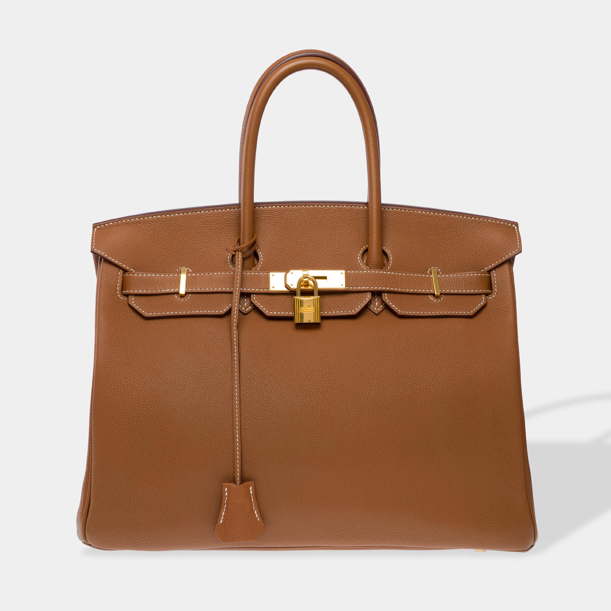 Splendid​ ​Hermes​ ​Birkin​ ​35​ ​cm​ ​handbag​ ​in​ ​Golg​ ​Too​ ​leather​ ​with​ ​white​ ​stitching,​ ​gold​ ​metal​ ​trim,​ ​double​ ​gold​ ​leather​ ​handle​ ​for​ ​hand​ ​a​ ​carry

Flap​ ​closure
Interior​ ​lining​ ​in​ ​gold​ ​leather,​ ​one​