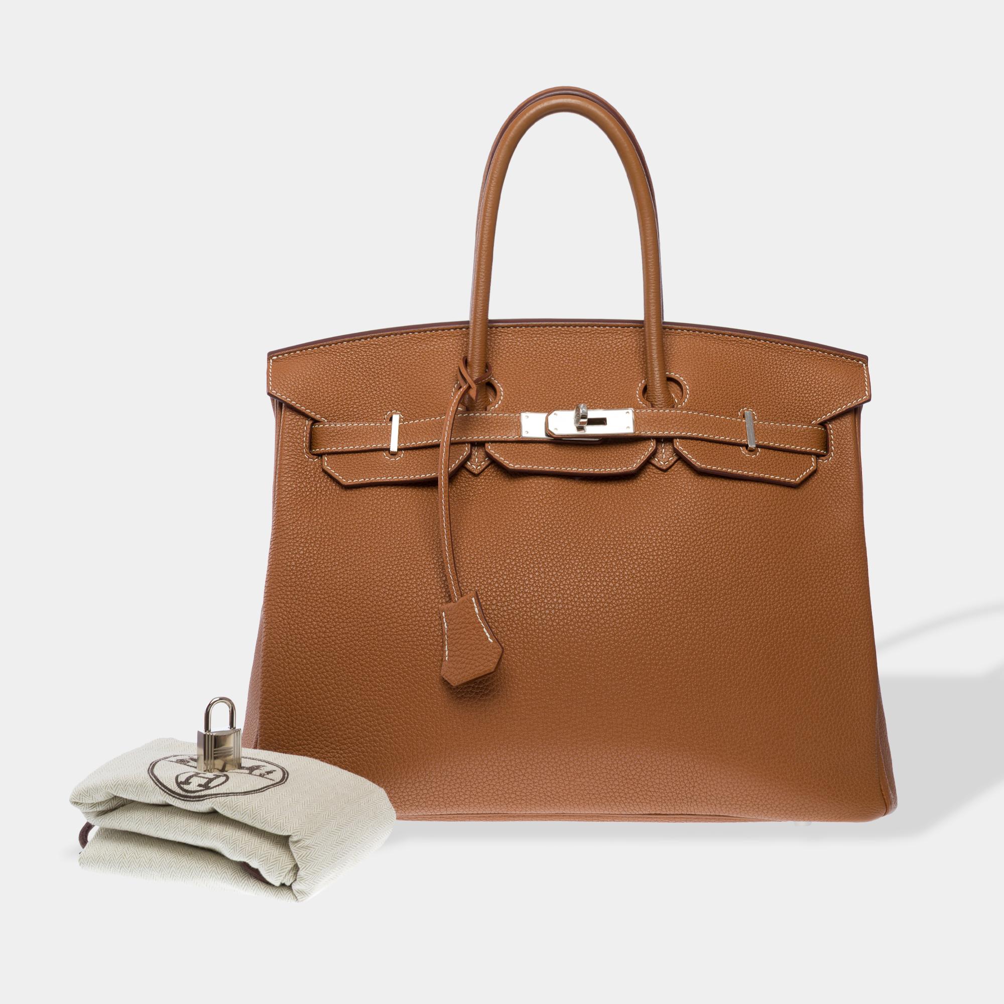 Splendid​ ​Hermes​ ​Birkin​ ​35​ ​cm​ ​handbag​ ​in​ ​Togo​ ​Gold​ ​(Fauve)​ ​leather​ ​with​ ​white​ ​stitching,​ ​palladium​ ​silver​ ​metal​ ​trim,​ ​double​ ​gold​ ​leather​ ​handle​ ​allowing​ ​it​ ​to​ ​be​ ​carried​ ​by​ ​hand

Flap​