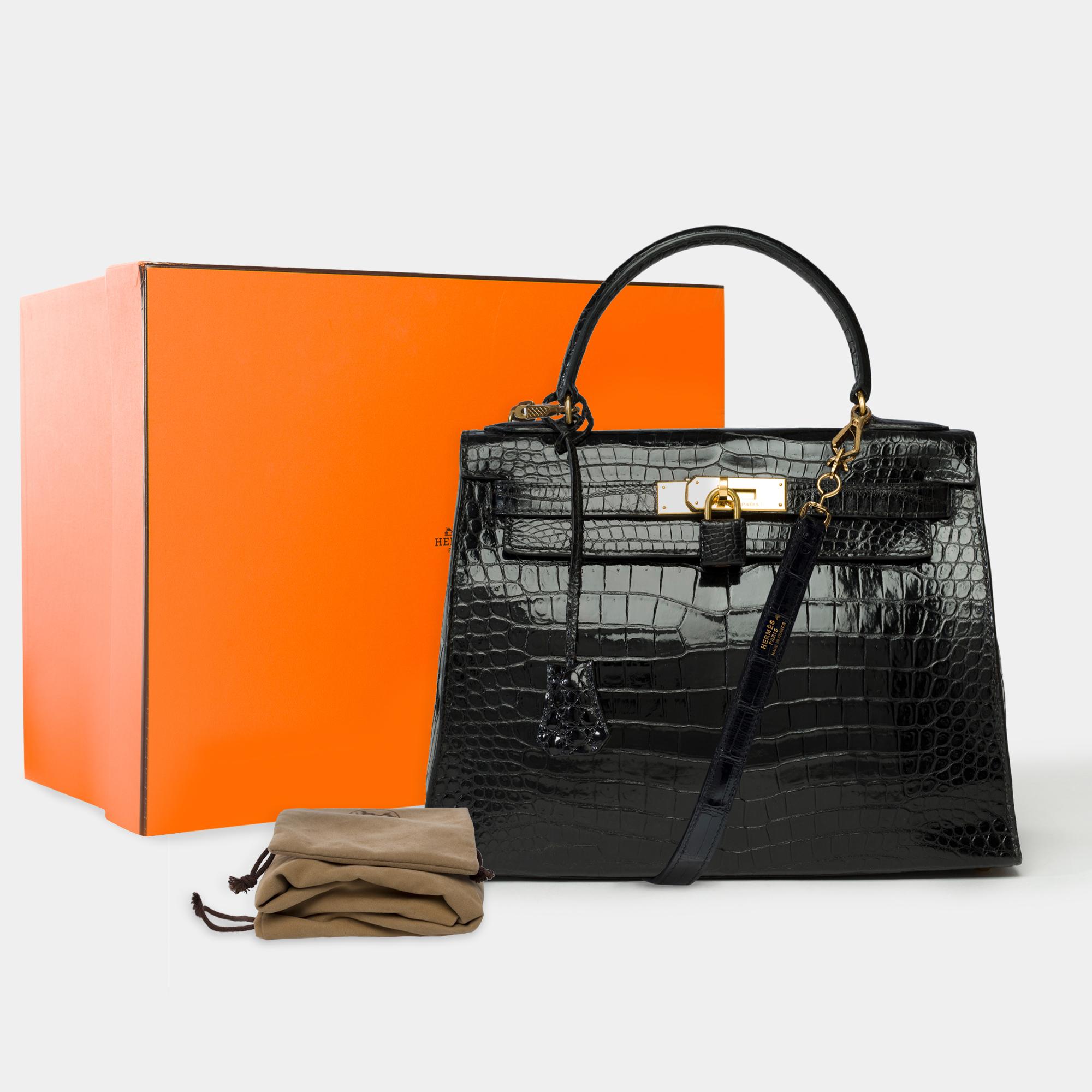 Exceptional​ ​Hermès​ ​Kelly​ ​28​ ​Sellier​ ​Bag​ ​in​ ​black​ ​Porosus​ ​crocodile,​ ​a​ ​removable​ ​black​ ​Porosus​ ​crocodile​ ​shoulder​ ​strap,​ ​gold-plated​ ​hardware,​ ​and​ ​a​ ​black​ ​crocodile​ ​leather​ ​handle​ ​for​ ​hand​ ​or​