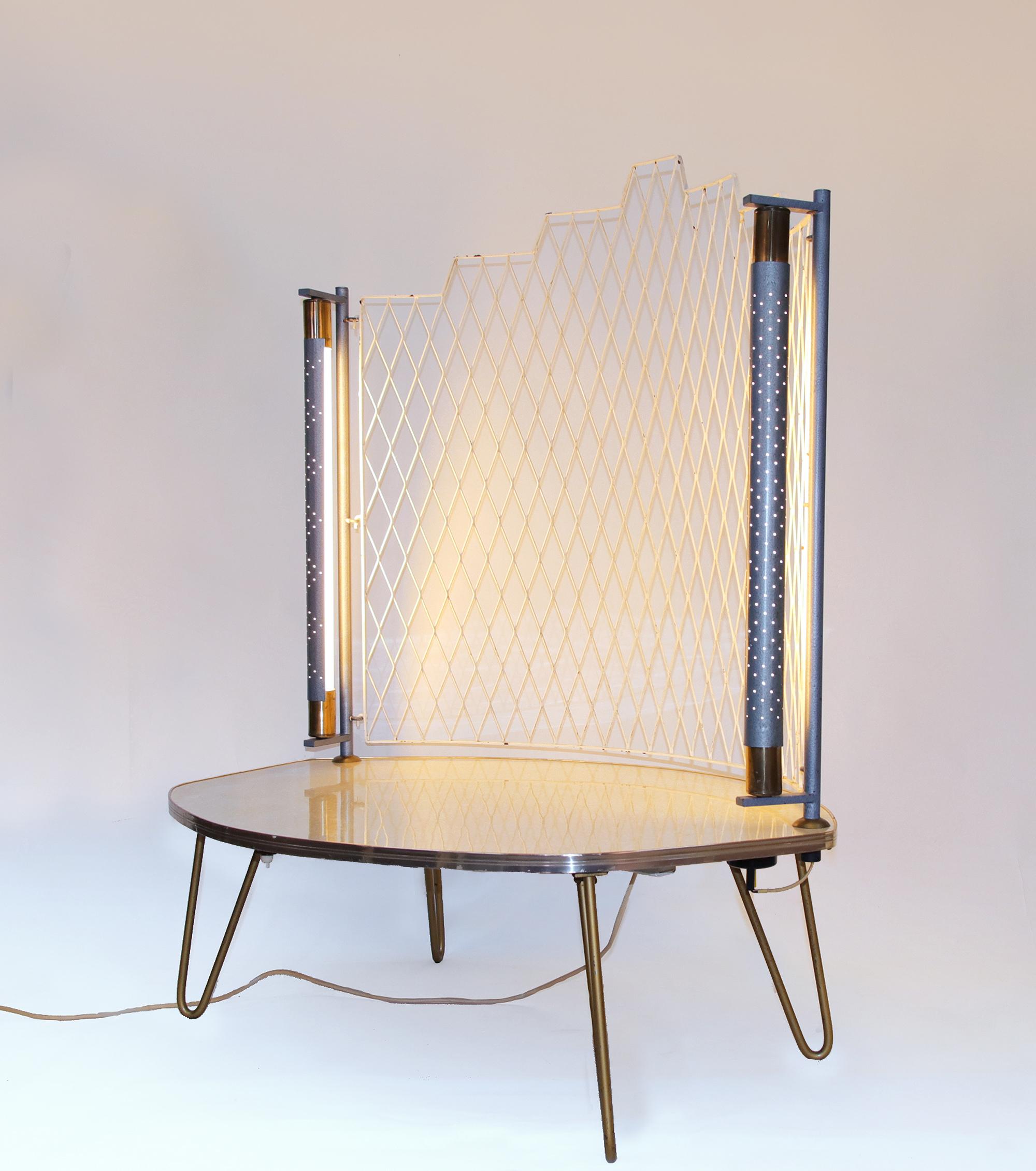 Amazing Mid-Century Modern asymmetric console or table used for a telephone, for plants or as a display.

The light reflects from the rotatable perforated shade of the fluorescent tubes shines through the dots.
The white honeycombed grid is