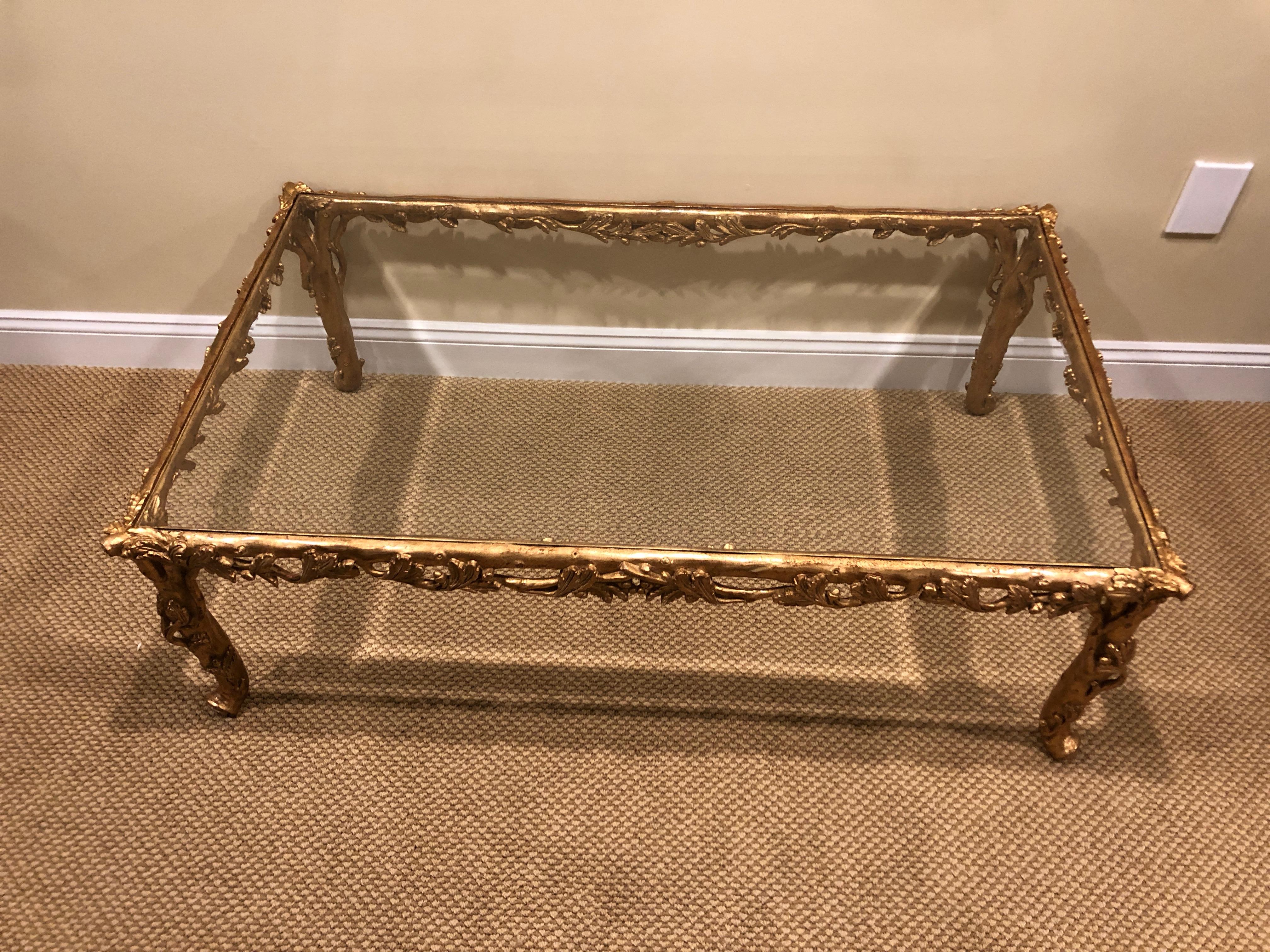 A very rare and uber glamorous coffee table signed and marked Made in Italy, having a elaborately decorated sculpted gold resin base. The base is amazingly light because of the material, but strong enough to support a handsome beveled piece of glass.