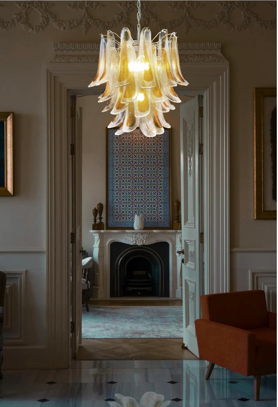 Enorme lampadario vintage italiano di Murano composto da 41 petali di vetro (trasparente e ambra) in una struttura di metallo verniciato oro. Periodo: fine del XX secolo
Dimensioni: 46 pollici (117 cm) di altezza con catena; 25,60 pollici (65 cm) di