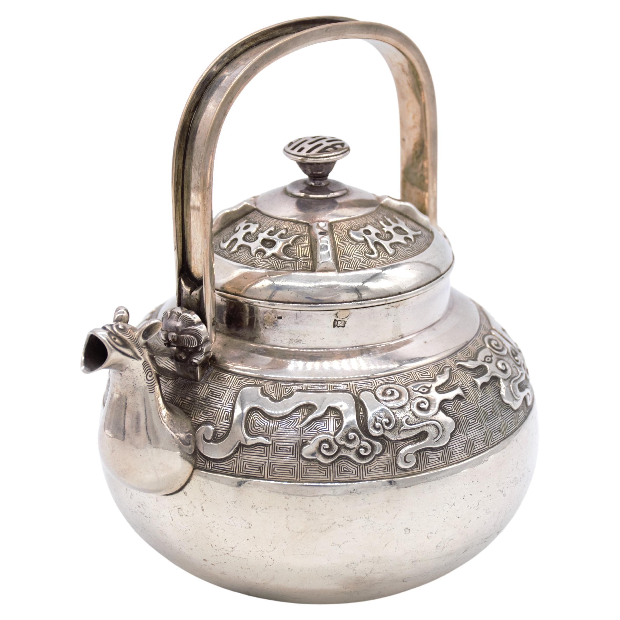 amazing rare archaistic style silver ewer or tea pot with cover, the design is Of archaistic style dragons on the main frieze and on the cover, this style came from ancient Chinese art, the spout is designed as the head of a dragon or a mythical