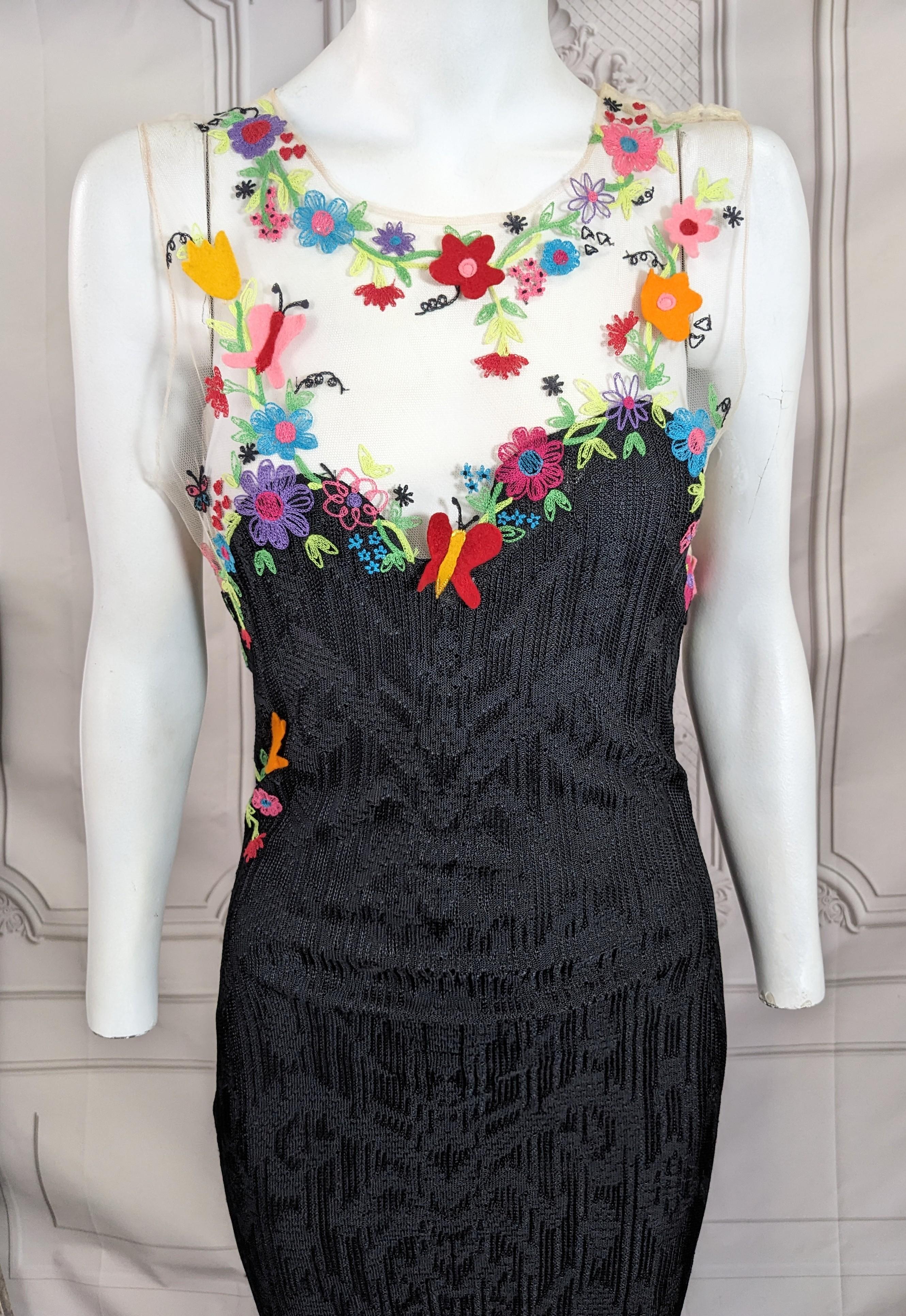 Superbe robe de soirée John Galliano automne/hiver 2000 en maille pointelle rayonne-soie noire, brodée et appliquée de fleurs et de papillons en laine multicolore autour de l'encolure et des épaules en tulle transparent. Le panneau arrière