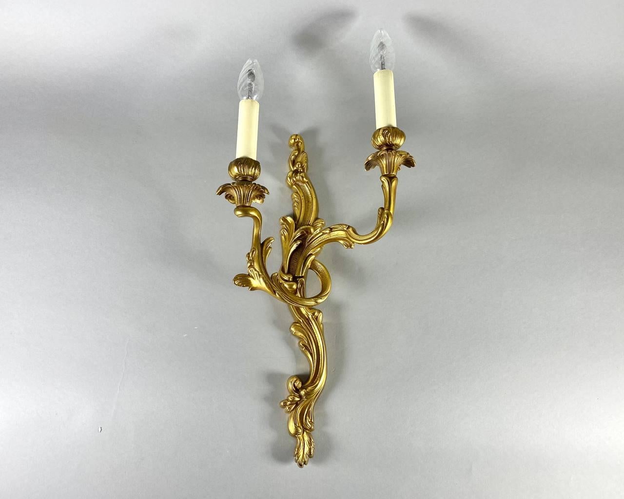 Beautiful Large Louis XV style wall lamp with two sconces. Vintage.

 Support in gilded bronze and handcrafted by craftsmen.

 The decor consists of stylized acanthus scrolls intertwined with the Louis XV style.

 This Unique wall sconce will