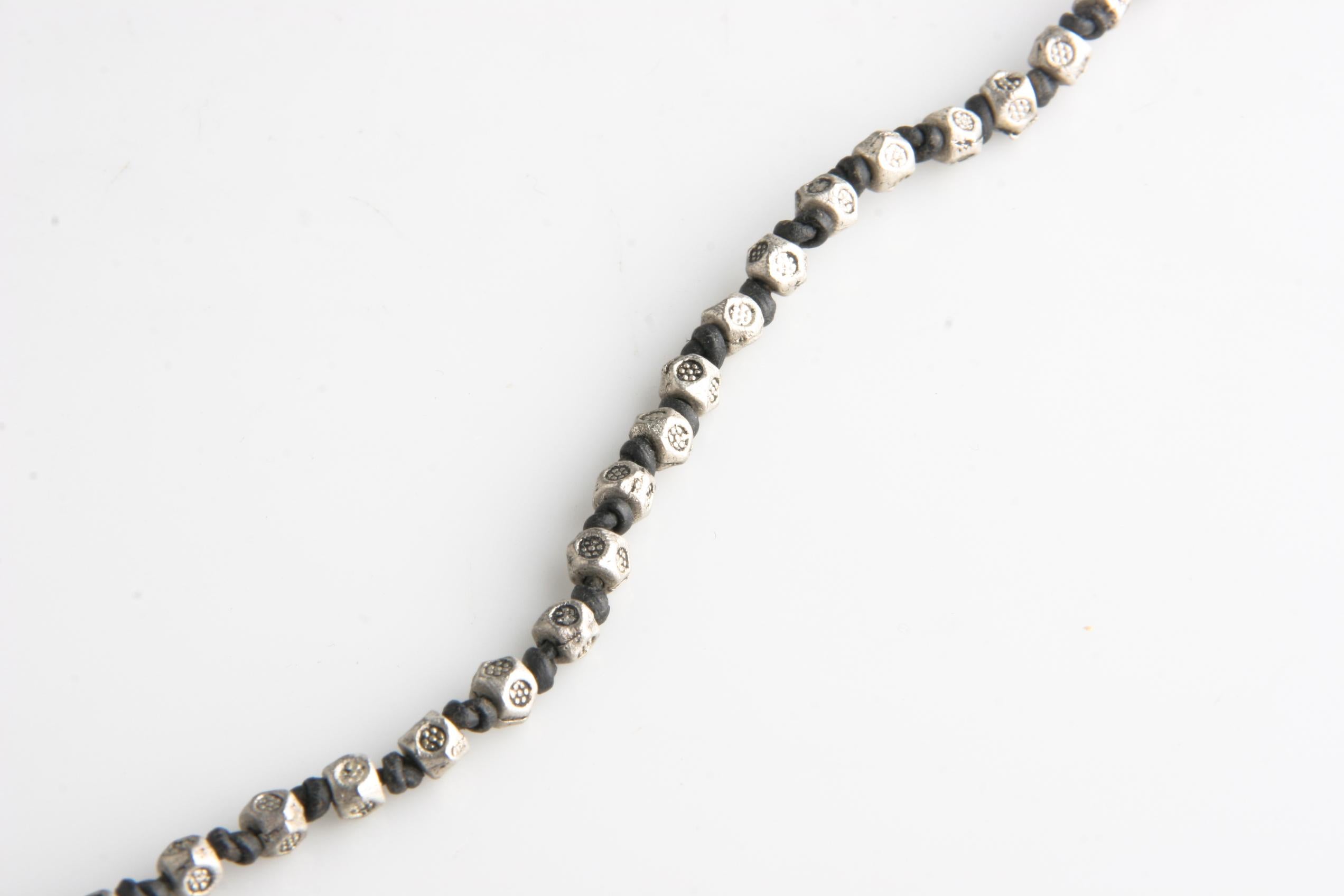 Collana in pelle molto lunga.
Presenta perline in silverplate dalla forma unica e dal design anticato.
Ogni perlina è separata da un nodo.
Include una chiusura magnetica.
Lunghezza: 46 pollici.
Peso: 38,8 grammi.