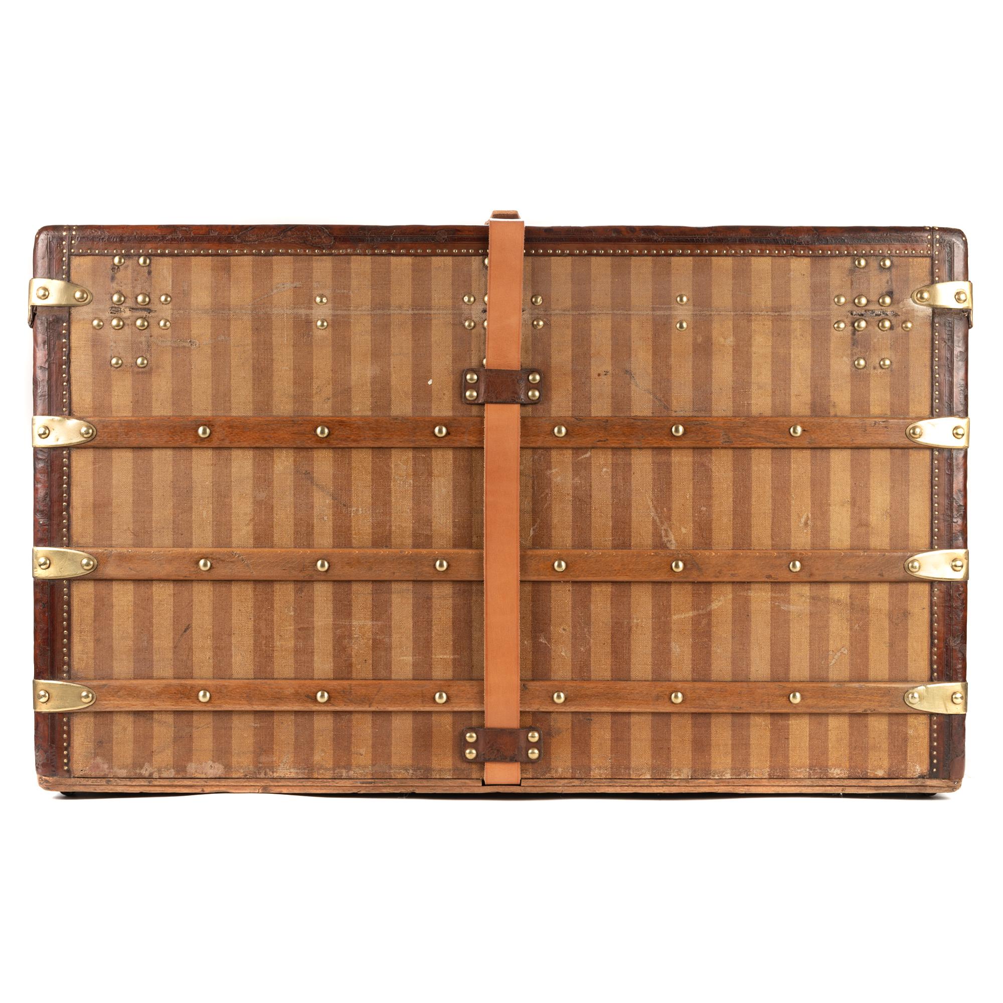 LOUIS VUITTON, Paris-London
Wooden box upholstered with stripes.
Carries inside a trunk-shaped label of the house marked LOUIS VITTON 289 Oxford Street, Regent Circus, London, rue Scribe in Paris, numbered 12475 and carries a stamp of the house in