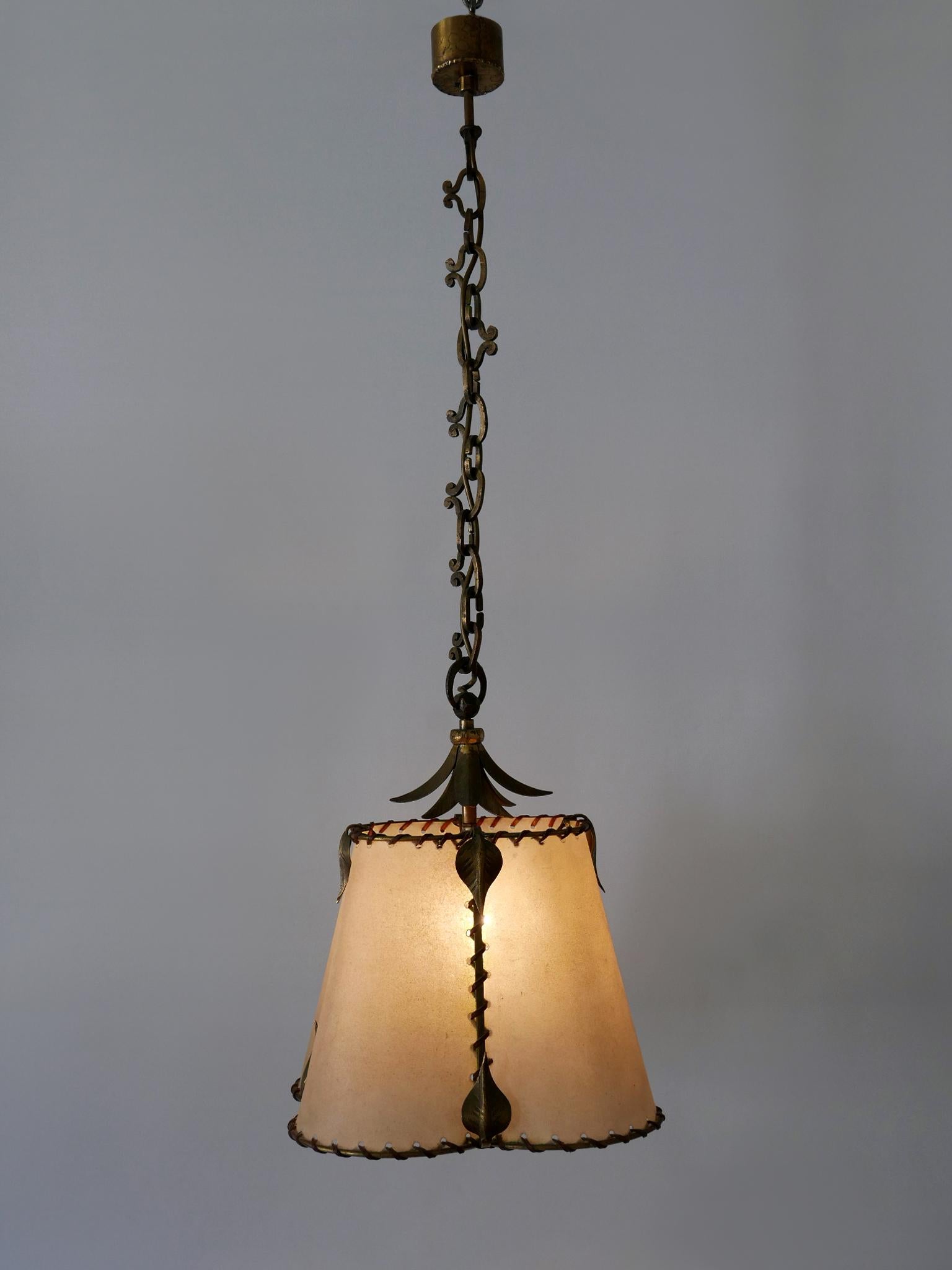 Extremely rare, elegant and highly decorative Mid-Century Modern parchment paper and wrought brass pendant lamp or hanging light. Manufactured probably in Germany, 1960s.

Executed in parchment, brass and leather, the pendant lamp needs 1 x E27 /