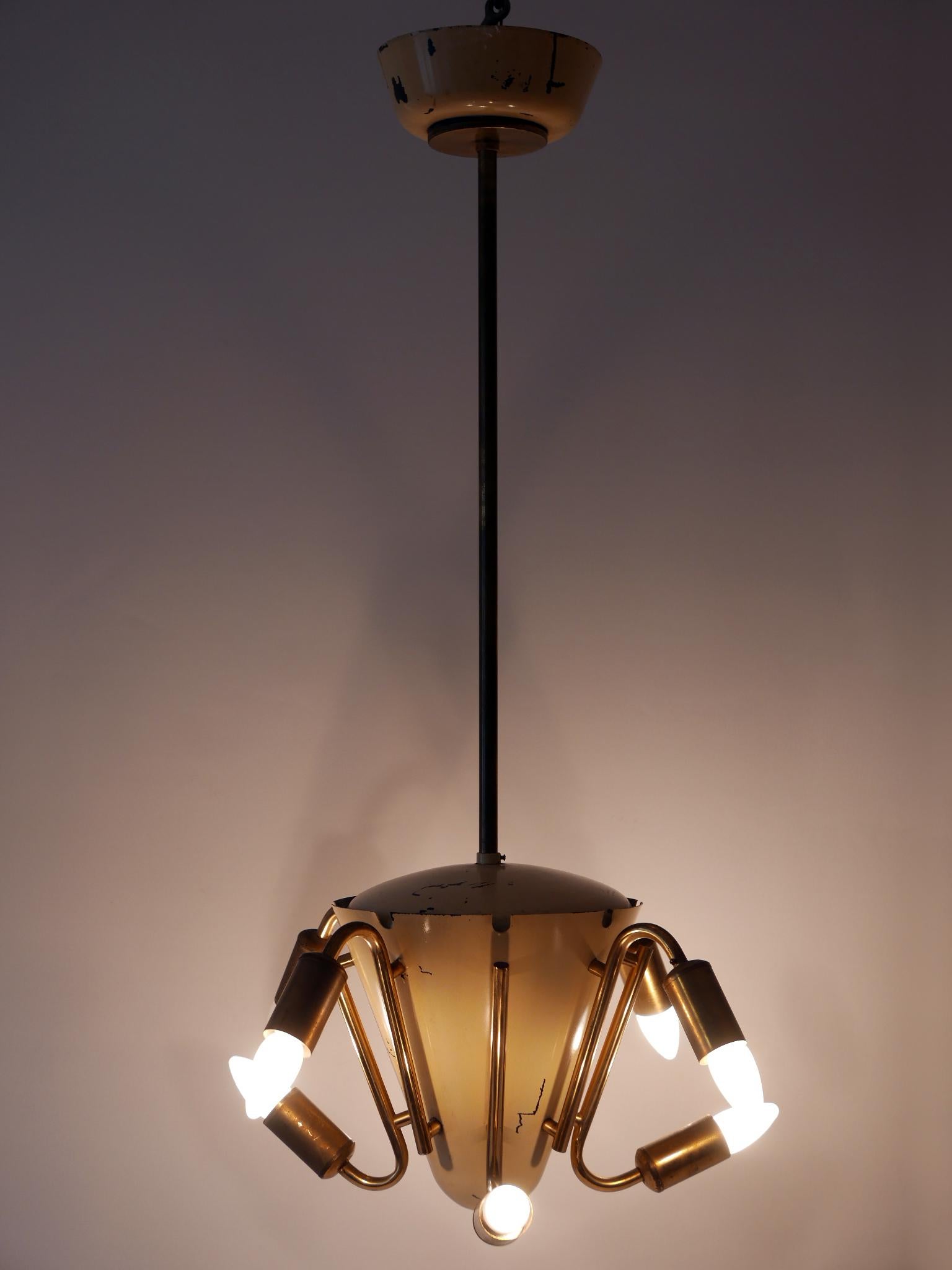 Exceptional eight-armed Mid-Century Modern Sputnik chandelier or pendant lamp. Designed and manufactured in 1950s, Germany. I think this is a modified piece from a fluorescent tube chandelier.

Executed in partly beige enameled brass, the