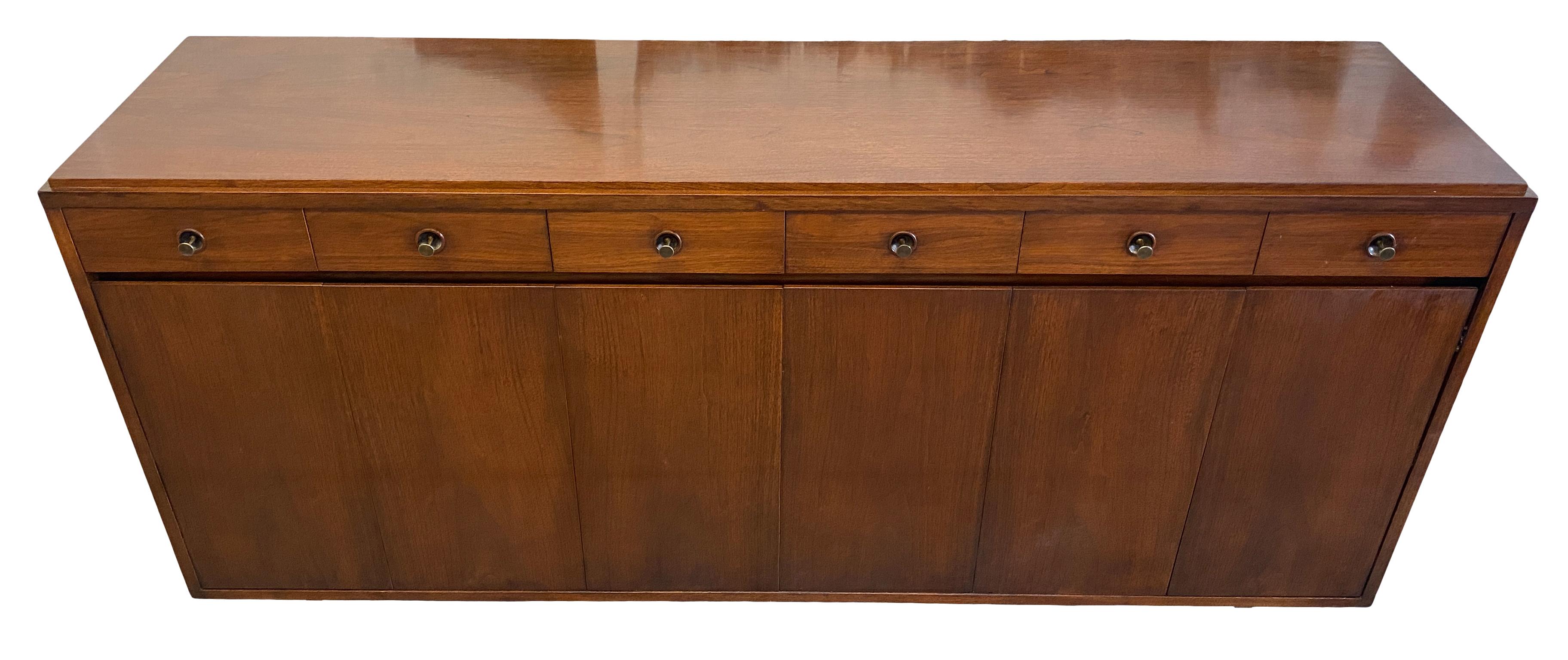 Rare midcentury American designer Paul McCobb walnut 14-drawer dresser credenza #8053. Original finish in beautiful vintage condition, has front folding walnut front accordion doors with magnets in amazing condition, all solid walnut with a dark