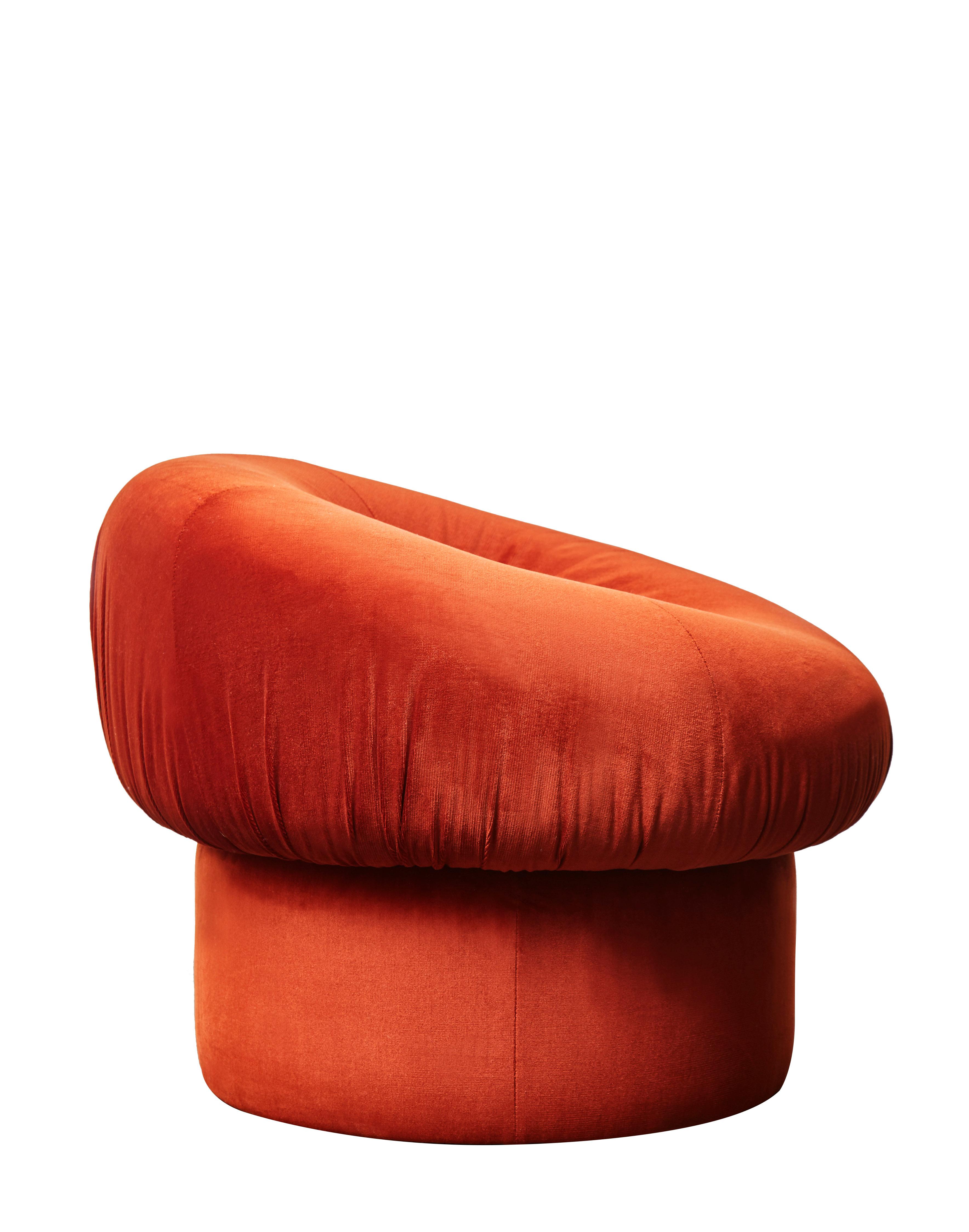 This pair of vintage armchairs/poufs has been reupholstered with terracotta velvet fabric.