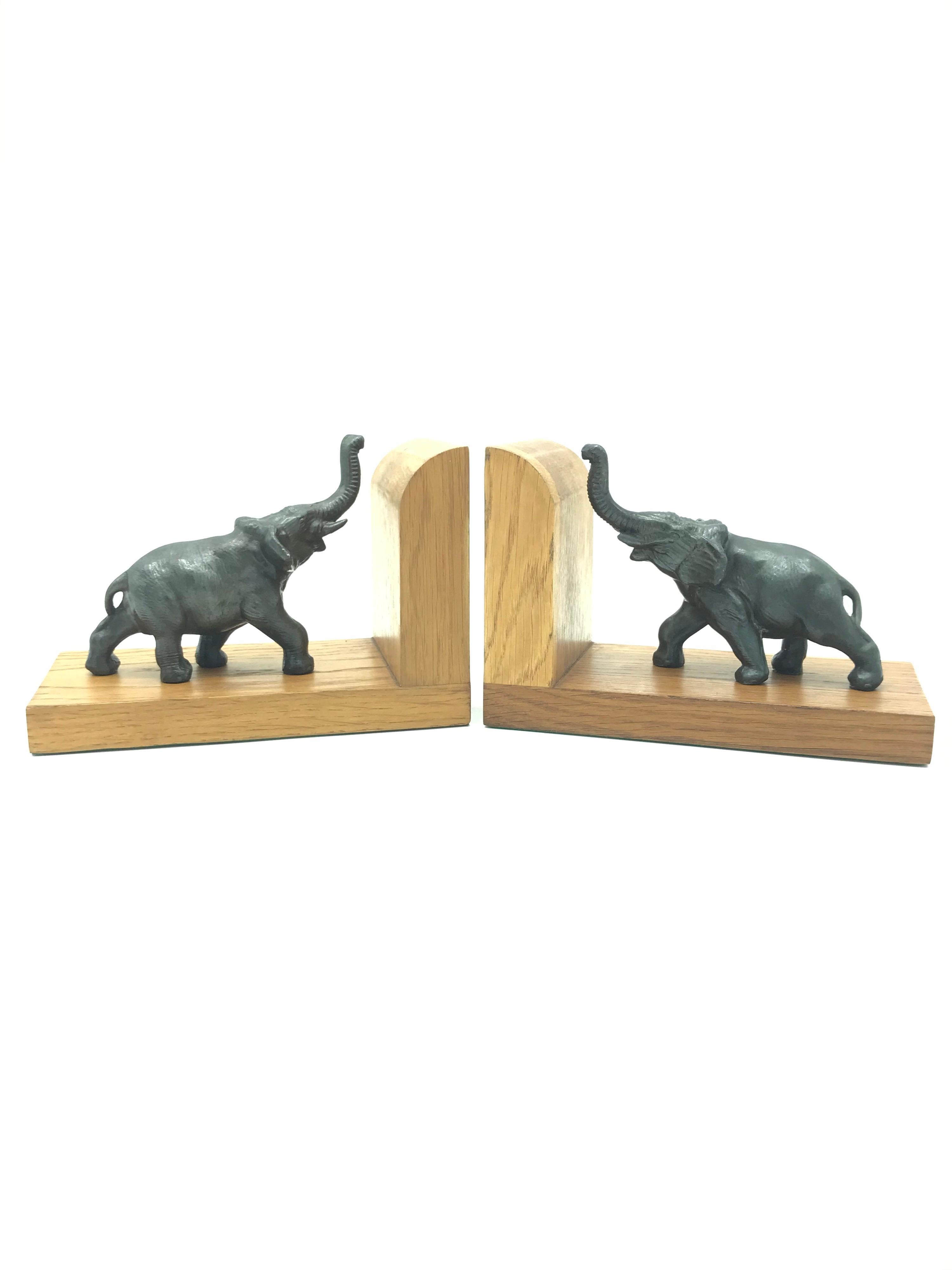 Amazing pair of Art Deco elephant book ends from the 1930s in oak. 
The elephants are cast bronze and depict two young elephants supporting the books. 
In great vintage condition and quality.