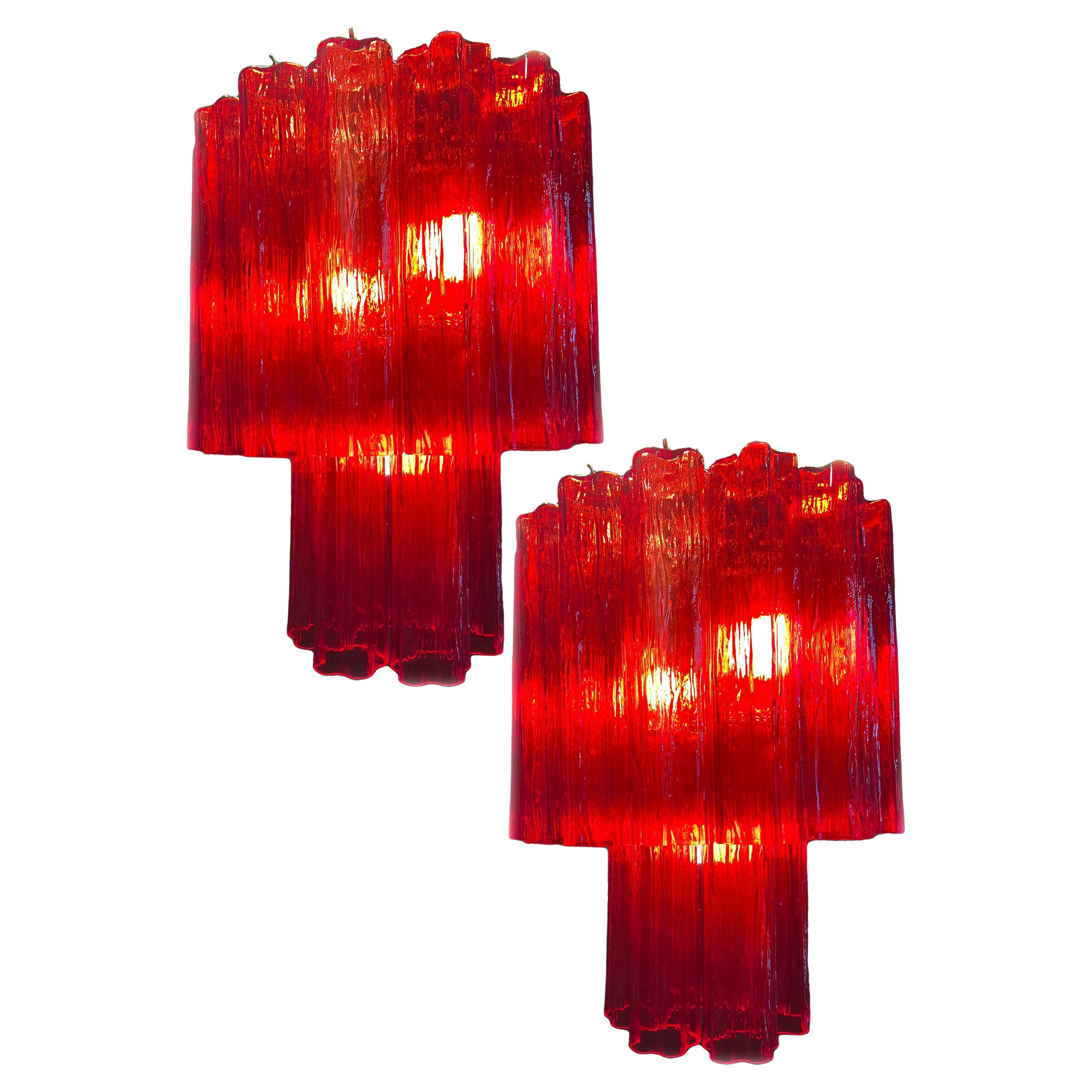 Charming pair of Murano chandeliers. The ruby red color makes the chandelier magnetic and fascinating..The height without chain is 72 cm.